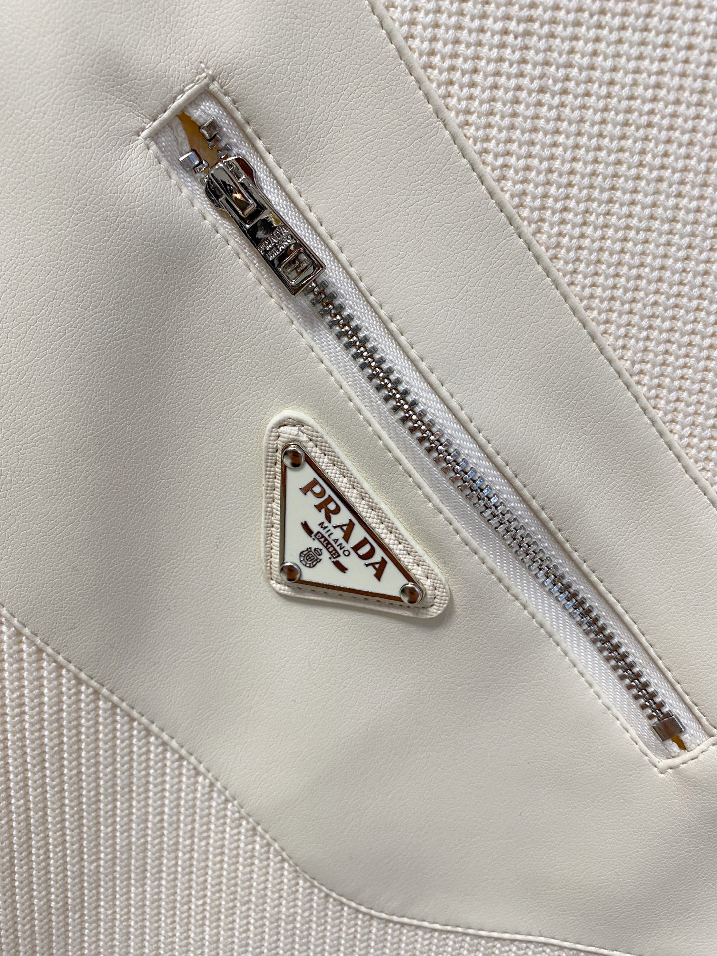 。普拉达 2025秋冬  羊毛混纺套头针织卫衣  几何拼皮的口袋设计 很有亮点，标志字母纽扣 细节上凸显