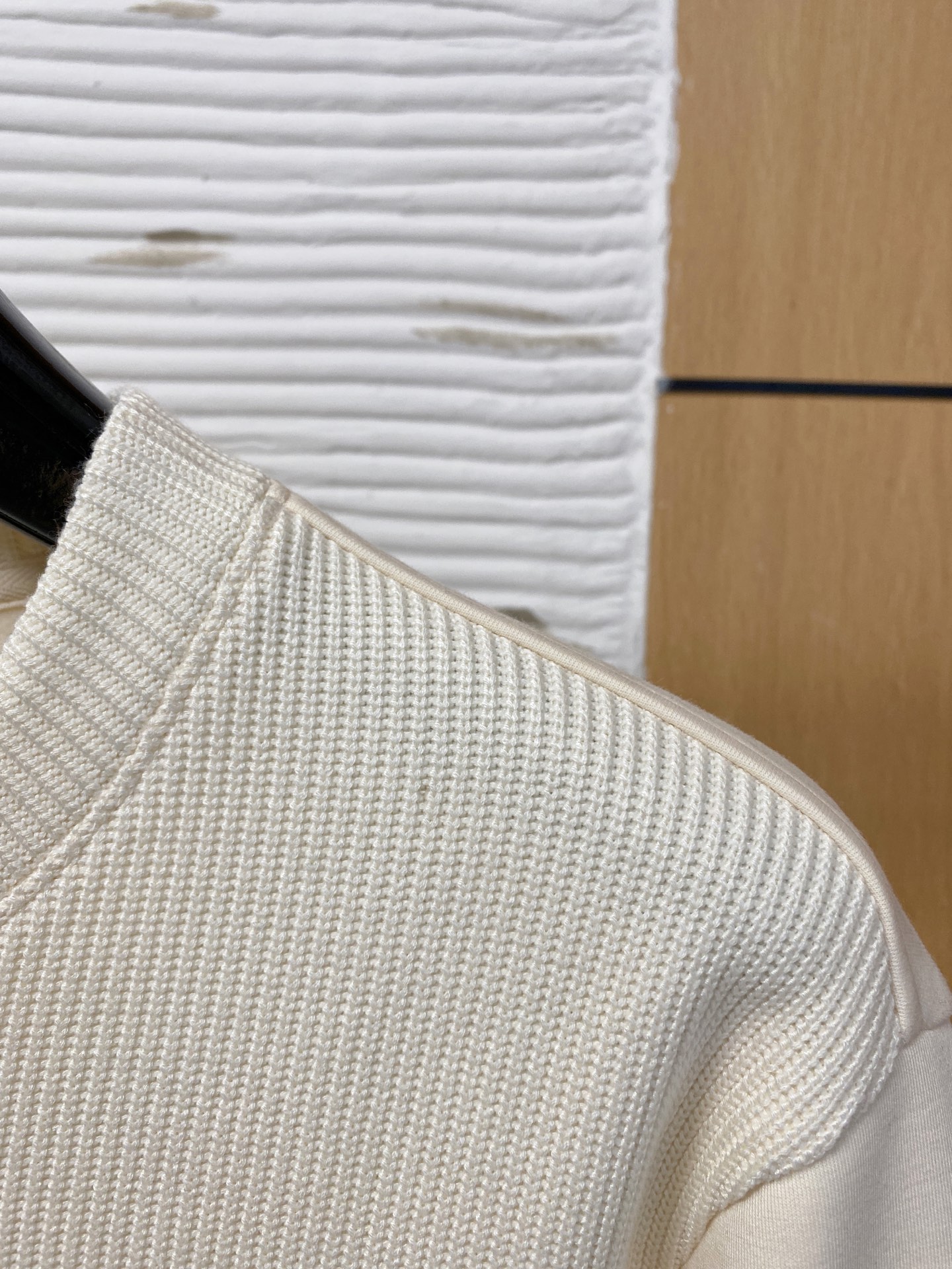 。普拉达 2025秋冬  羊毛混纺套头针织卫衣  几何拼皮的口袋设计 很有亮点，标志字母纽扣 细节上凸显