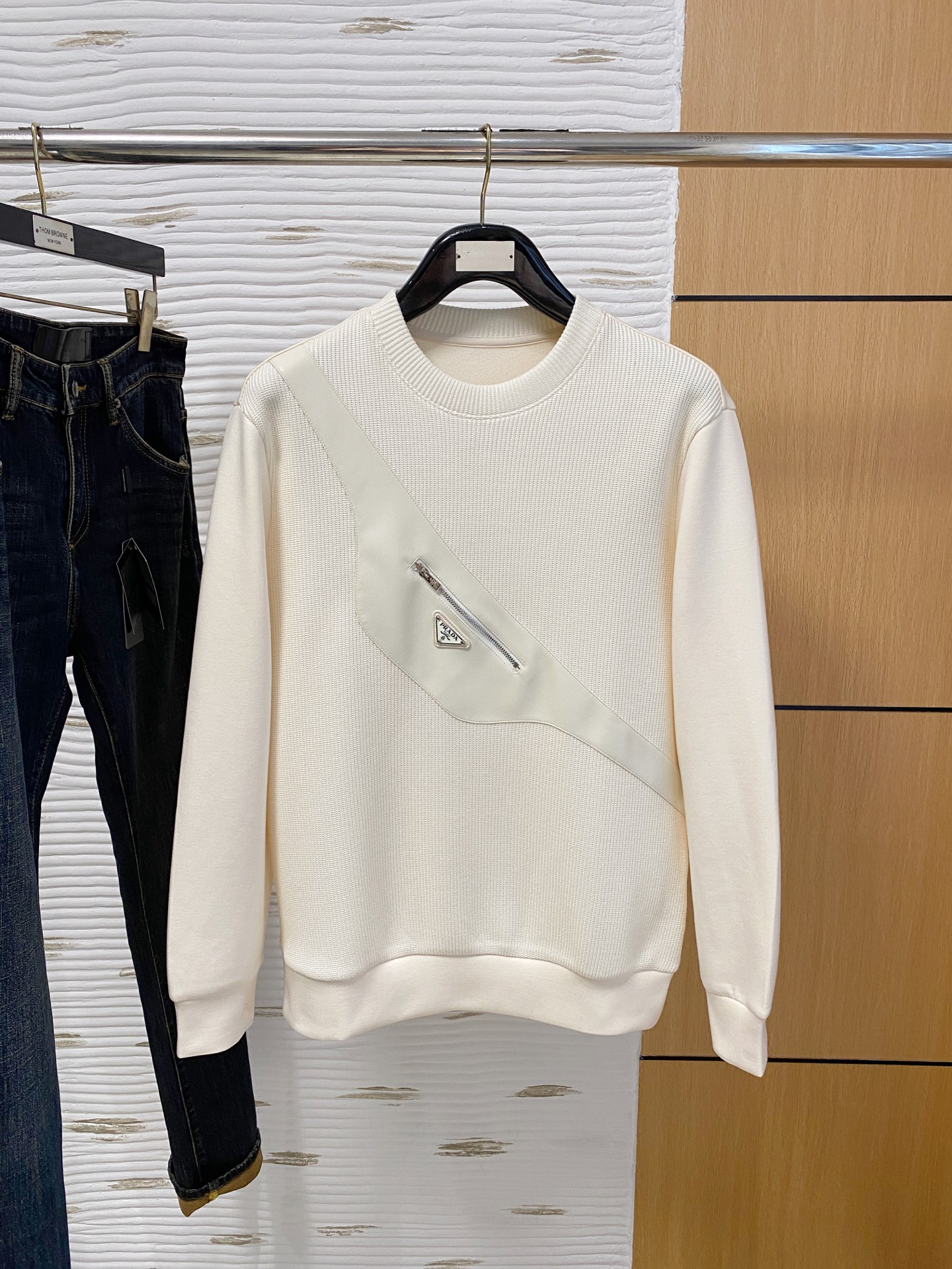 。普拉达 2025秋冬  羊毛混纺套头针织卫衣  几何拼皮的口袋设计 很有亮点，标志字母纽扣 细节上凸显