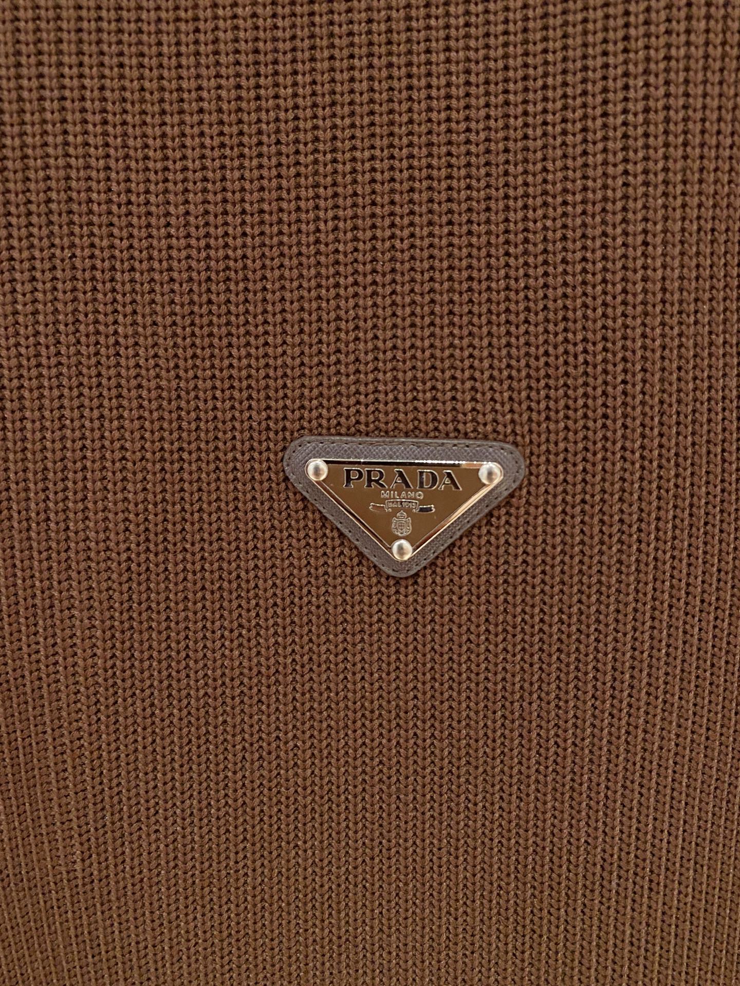 。普拉达 2025秋冬 羊毛混纺套头针织卫衣 几何拼皮的口袋设计 很有亮点，标志字母纽扣 细节上凸显质感