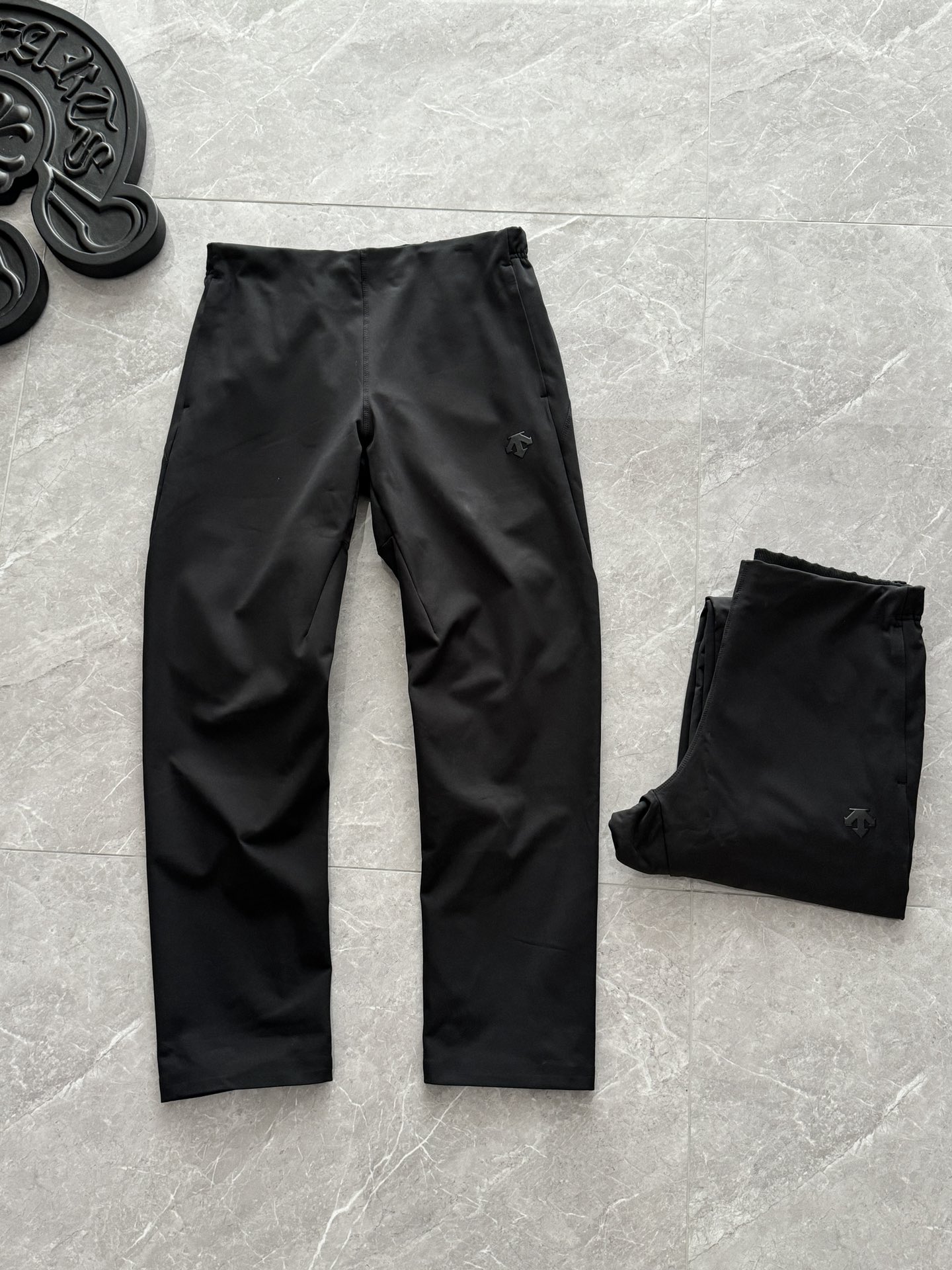 💰240
DESCENTE迪桑特TRAINING综训系列加厚男士梭织运动长裤
专为秋冬户外训练设计。它采用高密度梭织软壳面料，结合防水透湿科技，在保持防风锁温的同时，能快速导出运动时产生的湿气，避免闷热感。裤子内里增加的保暖层触感细腻，能有效储存体温，提升保暖效果，南方地区一条即可过冬。其3D立体剪裁贴合腿部曲线，从大腿到膝盖的自然内收线条，在修饰腿型的同时确保了高抬腿、深蹲等动作的灵活性，全天候防护：面料经过防泼水处理，能从容应对小雨雪天气；高密度结构还能有效阻隔冷风侵入。

• 💨 透气速干：优异的透气速干性能，可迅速排走汗湿，保持体表干爽舒适，避免运动后着凉。

• ✂️ 立体修身版型：符合人体工学的立体拼接设计，臀胯部位留有充足活动空间，利落挺括不臃肿，运动休闲皆宜。

• 🩹 耐用且易打理：面料具备抗皱、抗摩擦特性，耐磨耐洗，多次穿着后仍能保持良好版型。细节彰显专业
本款长裤在细节上充分考虑运动者的实际需求。弹力松紧腰头内置抽绳，可自由调节松紧，贴合不卷边也不勒肚子。两侧配有拉链插手口袋，重要物品存放安全不易滑落。
后膝部的立体拼接和裤脚的微收窄设计，进一步减少了运动阻力，并优化了整体轮廓。经典的迪桑特品牌标识点缀于后腰或裤身，低调彰显品质。
多场景适用
这条长裤的巧妙之处在于其出色的场景适配力。无论是健身房内的力量训练、秋冬季节的户外跑步，还是作为日常都市通勤的着装，它都能完美胜任。
其简约大气的设计语言，搭配黑色、卡其、藏青等经典配色，轻松匹配从专业运动到休闲生活的多种风格需求。
颜色：黑色 
尺码     规格          腰围      裤长        体重
M       170             89         101     130-140
L       175               88         103.5  150-160
XL      180              94         106       170-180
2XL    185             100       107.5     180-190