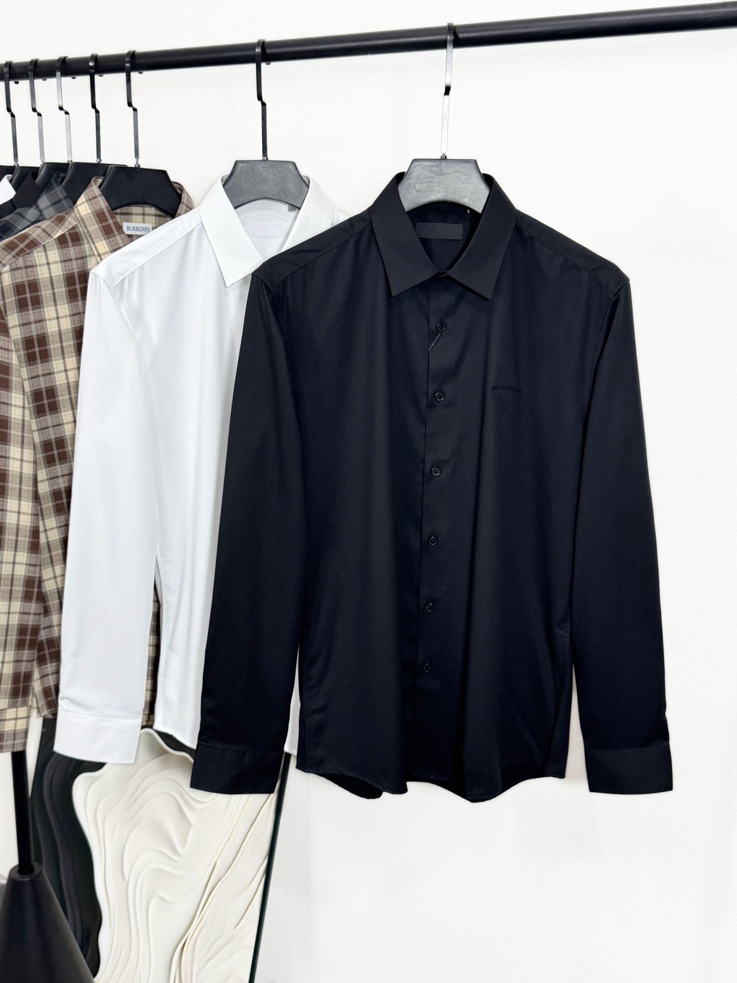 NO:141868,(New Product) PRA25SS Spring and Summer New White Cotton Poplin Fashion Lapel Shirt Men's Classic Triangle Lapel Business Casual Long Sleeve Shirt!  Trading companies have sparse channels and are released on the official website at the same time!  At the intersection of fashion and classics, P Home has launched this brand new shirt with its unique perspective and exquisite craftsmanship!  It not only pursues the ultimate comfort and quality in fabrics, but also shows the brand's unique luxury and exquisiteness in details!  This shirt is made of customized dense cotton poplin, and the pure cotton material ensures a silky and comfortable touch!  It seems to be integrated with the skin when worn, skin-friendly without getting greasy, bringing the wearer a whole day of comfort experience!  The details reflect the strict quality requirements of P home. The customized brand letter engraved mother-shell buckles not only have a gentle luster and full texture, but also demonstrate the unique charm of the brand in the subtleties!  The triangle label patch design on the chest pocket is simple and clean, but it does not lose the luxury of the brand, adding a dazzling fashion element to the overall look!  The basic and regular style design is suitable for formal wear in business occasions, and can also meet the relaxed matching of casual time. Whether it is to attend important meetings with suits and ties, or enjoy the afternoon with jeans, it can perfectly show your elegance and confidence!  Size M-XXXL M size shoulder width 44cm-bust 102cm-length 76cm-sleeve length 62cm L size shoulder width 45cm-bust 105cm-length 77cm-sleeve length 63cm Size shoulder width 46cm-bust 108cm-length 78cm-sleeve length 64cm XXL size shoulder width 47cm-bust 111cm-length 79cm-sleeve length 65cm XXXL size shoulder width 48cm-bust 114cm-length 80cm-sleeve length 66cm,,prada,jeans,shirts,business suit,alexander wang19860909(新品)PRA25SS春夏新款白色棉府绸时尚翻领衬衣男士经典三角标贴布商务休闲长袖衬衫！贸易公司渠道稀出,同步官网发售！在时尚与经典的交汇点上,P家以其独特的视角和精湛的工艺,推出了这款全新衬衫！它不仅在面料上追求极致的舒适与品质,更在细节上展现了品牌独有的奢华与精致！ 这款衬衫采用了客供定制的密织棉府绸,纯棉的材质确保了触感的丝滑舒爽！穿在身上仿佛与肌肤融为一体,亲肤而不腻身,为穿着者带来了一整天的舒适体验！细节之处更是体现了P家对品质的严苛要求,客供定制的品牌字母刻印母贝扣,不仅光泽温润、质感十足,更在细微之处彰显了品牌的独特魅力！而胸前口袋上的三角标贴布设计,简洁干净,却又不失品牌的奢华感,为整体造型增添了一抹亮眼的时尚元素！基础常规的版型设计,既适合商务场合的正式穿着,也能满足休闲时光的轻松搭配,无论是搭配西装革履出席重要会议,还是搭配牛仔裤享受午后时光,它都能完美展现你的优雅与自信！尺码M-XXXL M码肩宽44cm-胸围102cm-衣长76cm-袖长62cm L码肩宽45cm-胸围105cm-衣长77cm-袖长63cm 码肩宽46cm-胸围108cm-衣长78cm-袖长64cm XXL码肩宽47cm-胸围111cm-衣长79cm-袖长65cm XXXL码肩宽48cm-胸围114cm-衣长80cm-袖长66cm,,prada,jeans,shirts,business suit,alexander wang,Men's clothing