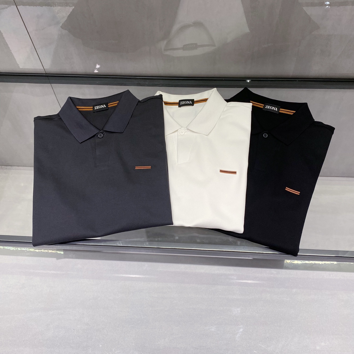 P230 25春夏新款ZEGNA起脚针织商务Polo，男士一粒扣V形领高端极简都市针织衫。意大利同渠道稀有订单，精英级男士必备的顶奢品牌ZE针织朱棣网眼棉面料，螺纹针织收口，极简的衣身造型，呈现出品牌的奢华气质范儿，都市型男必备！

来自意大利历史悠久尊贵奢华的顶奢品牌ZE在过去一百年来ZEGNR一直追求卓越的质量和手工。Z的东西无论是哪个方面都是最好的选择，要款式有款式，要上身效果有效果，要剪裁有剪裁，要设计有设计，而且经久不衰，上身的贵族气场无法替代，并且很有档次！

顶级针织棉质混纺质地，一粒扣V形领设计，面料整体的触感极为舒适，弹力十足亲肤效果高级，这种单品注定了就是为穿搭所生，完美的符合各种穿搭的所需。极为非凡，档次与魅力更是极为的出色亮眼，工艺能将其与材质精密结合，更能够彰显出品牌的档次与时髦气质所在！尺码：M-3XL 黑色，白色，灰色

M码    胸围100肩宽45 袖长21 衣长69
L码     胸围104 肩宽46 袖长22 衣长70
XL码   胸围108 肩宽47 袖长23 衣长71
2XL码 胸围112 肩宽48 袖长24 衣长72
3XL码 胸围16 肩宽49 袖长25 衣长73