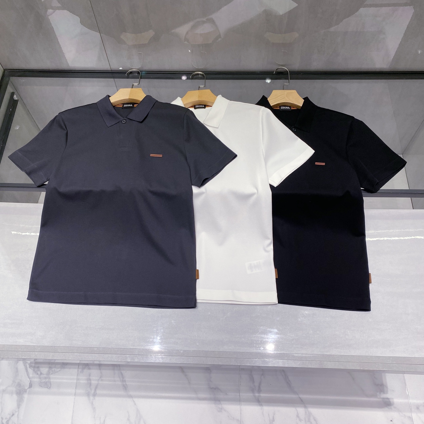 P230 25春夏新款ZEGNA起脚针织商务Polo，男士一粒扣V形领高端极简都市针织衫。意大利同渠道稀有订单，精英级男士必备的顶奢品牌ZE针织朱棣网眼棉面料，螺纹针织收口，极简的衣身造型，呈现出品牌的奢华气质范儿，都市型男必备！

来自意大利历史悠久尊贵奢华的顶奢品牌ZE在过去一百年来ZEGNR一直追求卓越的质量和手工。Z的东西无论是哪个方面都是最好的选择，要款式有款式，要上身效果有效果，要剪裁有剪裁，要设计有设计，而且经久不衰，上身的贵族气场无法替代，并且很有档次！

顶级针织棉质混纺质地，一粒扣V形领设计，面料整体的触感极为舒适，弹力十足亲肤效果高级，这种单品注定了就是为穿搭所生，完美的符合各种穿搭的所需。极为非凡，档次与魅力更是极为的出色亮眼，工艺能将其与材质精密结合，更能够彰显出品牌的档次与时髦气质所在！尺码：M-3XL 黑色，白色，灰色

M码    胸围100肩宽45 袖长21 衣长69
L码     胸围104 肩宽46 袖长22 衣长70
XL码   胸围108 肩宽47 袖长23 衣长71
2XL码 胸围112 肩宽48 袖长24 衣长72
3XL码 胸围16 肩宽49 袖长25 衣长73