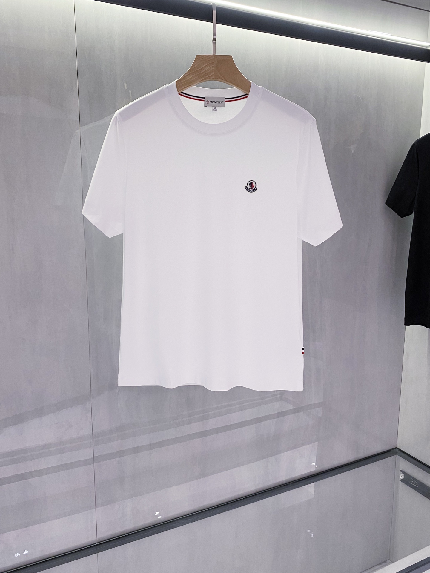 P220 经典款MOC25SS春夏新款平纹针织棉布圆领短Tee，男女同款红蓝字母标识刺绣休闲套头短袖T恤衫！贸易公司渠道稀出，领先官网发售！穿着它走在街头巷尾，你或许会不经意间吸引到路人的目光！他们或许会被你前幅徽章所吸引，或许会赞叹你整体的穿搭风格！

这款T恤衫采用客供定制平纹针织棉布，不仅触感柔软舒适，更在透气性与吸湿性上表现出色，确保了穿着者即使在炎炎夏日也能享受到清爽与自在！设计简约而不失大方，没有过多的繁复装饰，却能完美展现品牌的独特调性，前幅红蓝标识字母Logo装饰，它代表着品牌的历史与荣耀，仿佛在诉说着不为人知的故事！基础百搭休闲圆领版型设计，更是让日常穿搭变得从容不迫，无论是出席朋友聚会，还是进行户外休闲活动，这款T恤都能成为你的最佳拍档，让你在人群中脱颖而出！黑色/白色，两色入！尺码：M-XXXL

M码：肩宽45cm-胸围98cm-衣长68cm
L码：肩宽46cm-胸围102cm-衣长70cm
XL码：肩宽47cm-胸围106cm-衣长72cm
XXL码：肩宽48cm-胸围110cm-衣长74cm
XXXL码：肩宽50cm-胸围114cm-衣长76cm