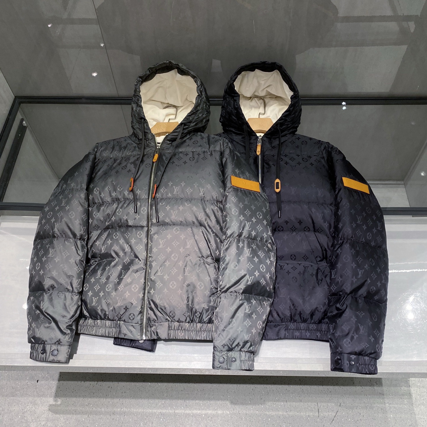 。 (新品)Louis Vuitton路易威登秋季新款衣袖皮标斜插口袋连帽抽绳羽绒服老花图案休闲连帽羽绒