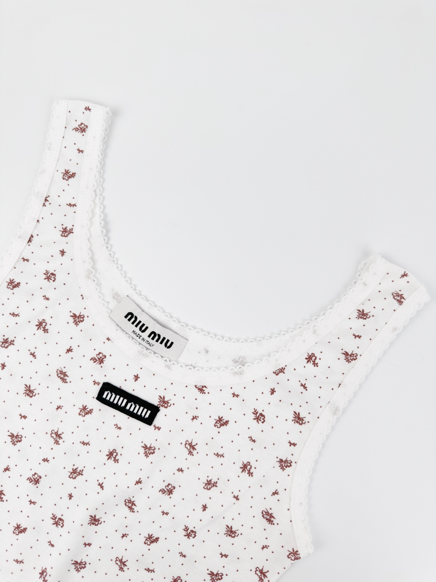 Miu Miu 标志性MiuMiu标签点缀于胸前 增添品牌魅力 衣身铺满雾感柔金花卉 少女感与 感平衡得恰到好处