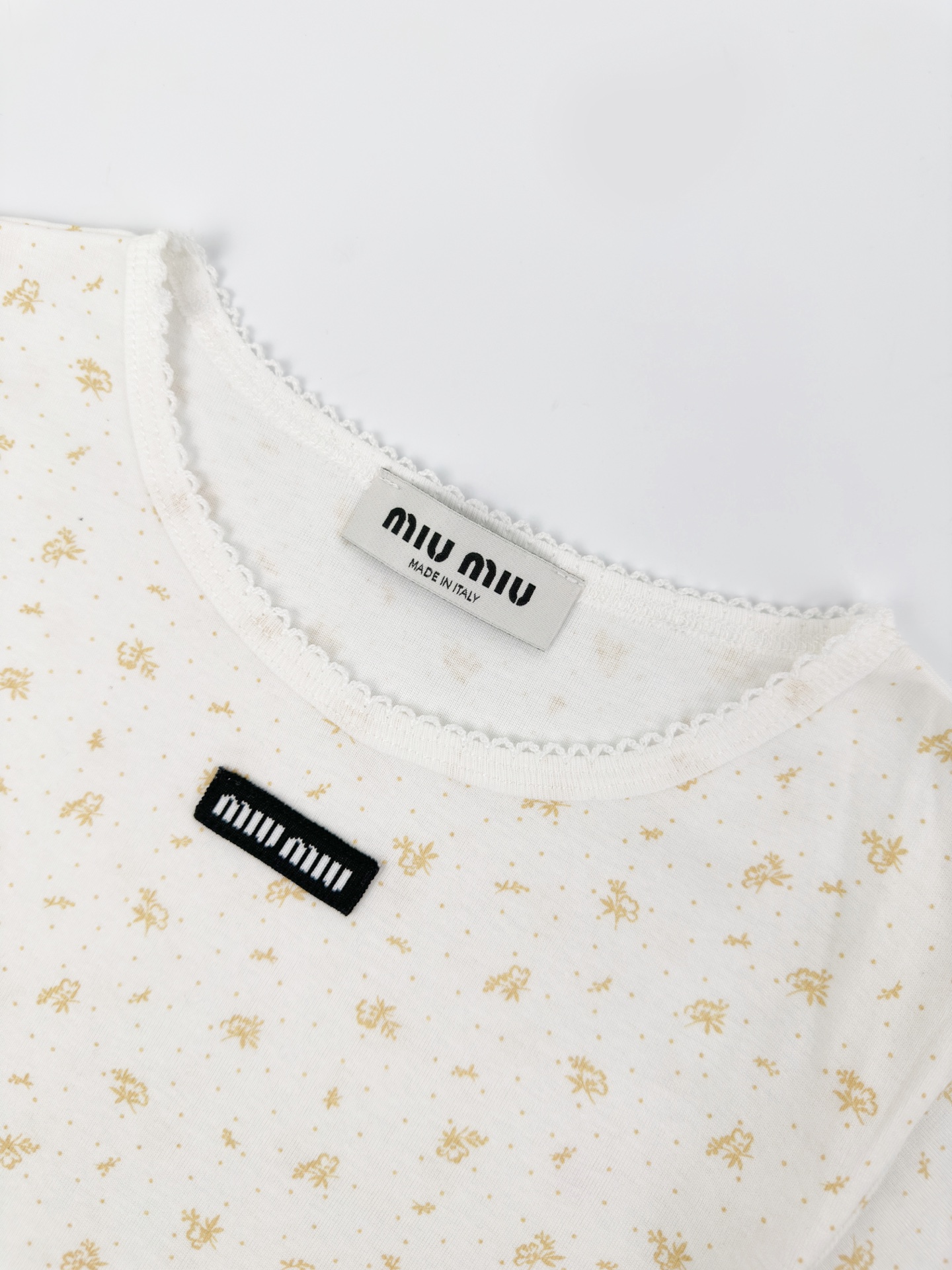 Miu Miu 标志性MiuMiu标签点缀于胸前 增添品牌魅力 衣身铺满雾感柔金花卉 少女感与 感平衡得恰到好处