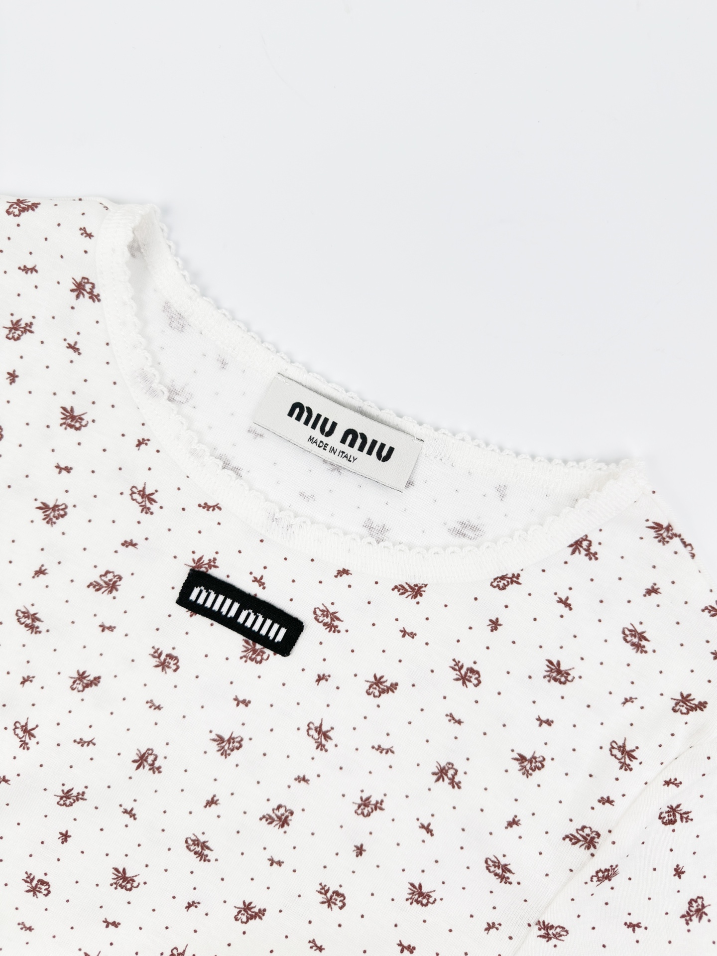 Miu Miu 标志性MiuMiu标签点缀于胸前 增添品牌魅力 衣身铺满雾感柔金花卉 少女感与 感平衡得恰到好处