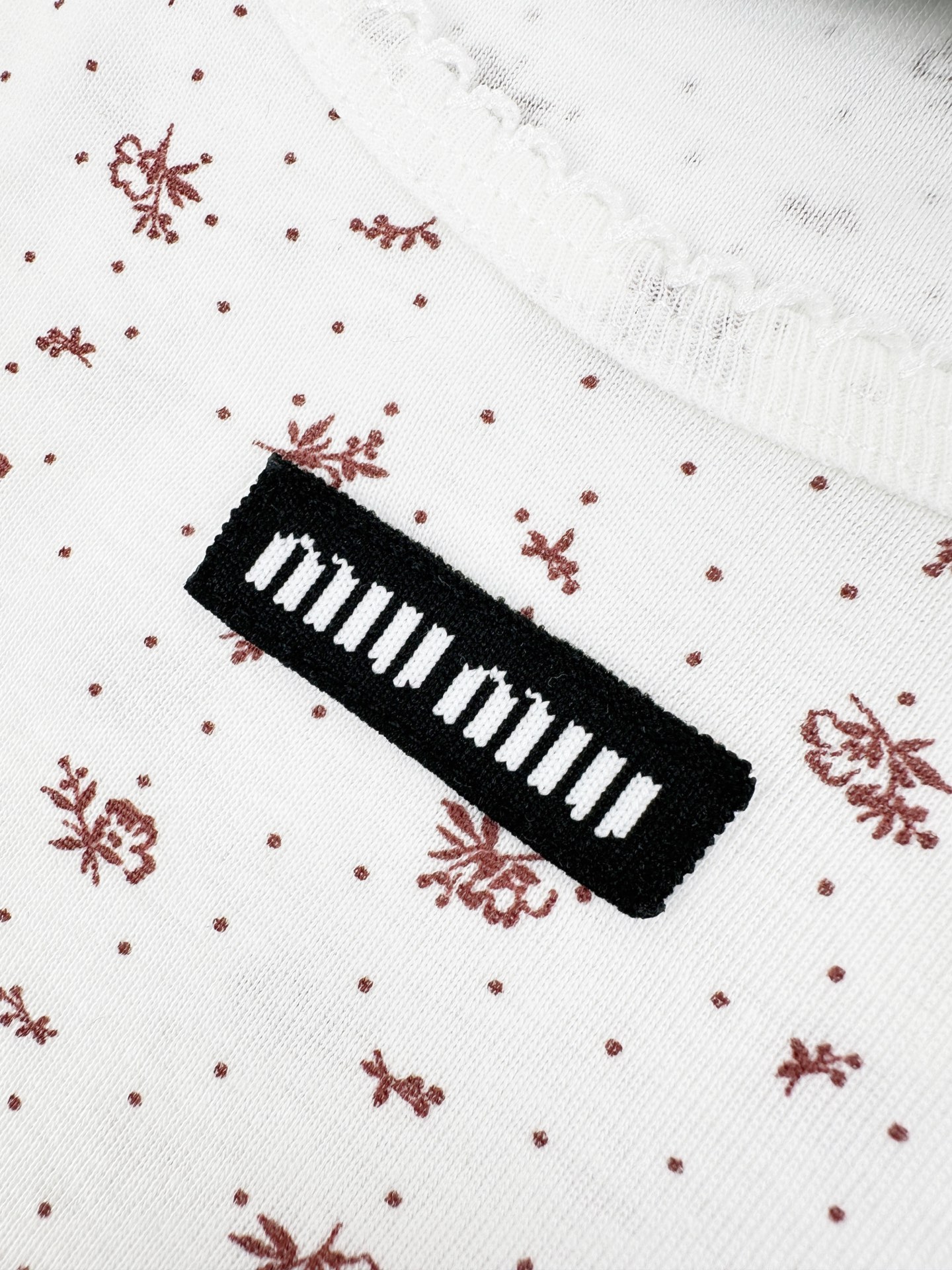 Miu Miu 标志性MiuMiu标签点缀于胸前 增添品牌魅力 衣身铺满雾感柔金花卉 少女感与 感平衡得恰到好处