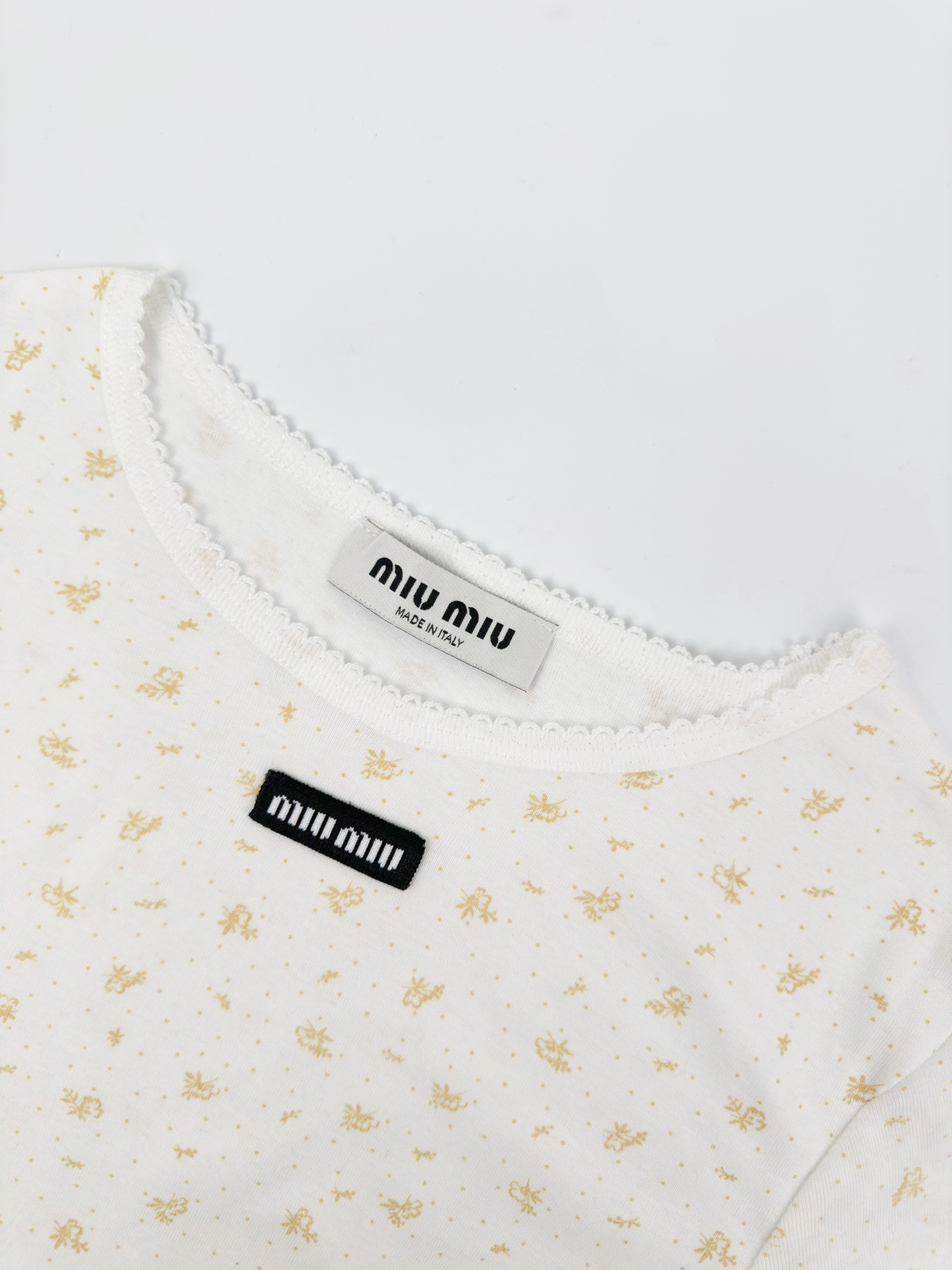 Miu Miu 标志性MiuMiu标签点缀于胸前 增添品牌魅力 衣身铺满雾感柔金花卉 少女感与 感平衡得恰到好处