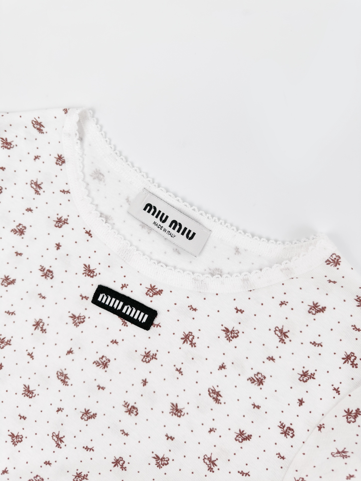 Miu Miu 标志性MiuMiu标签点缀于胸前 增添品牌魅力 衣身铺满雾感柔金花卉 少女感与 感平衡得恰到好处