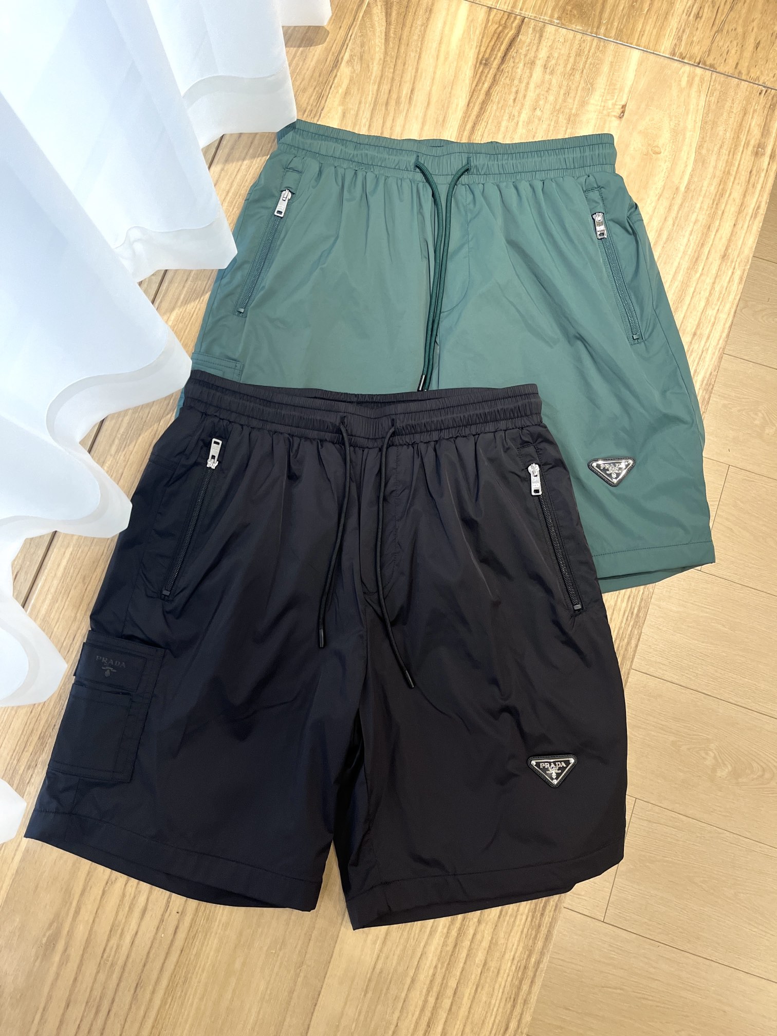 NO:148893,Prada* Prada New Summer Shorts Iconic Enamel Metal Triangular Logo Shorts with elastic rope waist, easy to wear to interpret sporty style and modern style #88312# Color Black Green Number 48-56,,prada,prada,shorts,alexander wang19860909Prada*普拉达 25年夏季新款短裤 标志性珐琅金属三角形徽标短裤,配有弹力束绳腰头、轻松穿搭便能诠释运动风范和现代格调 #88312# 颜色黑色 绿色 码数48-56,,prada,prada,shorts,alexander wang,Men's clothing