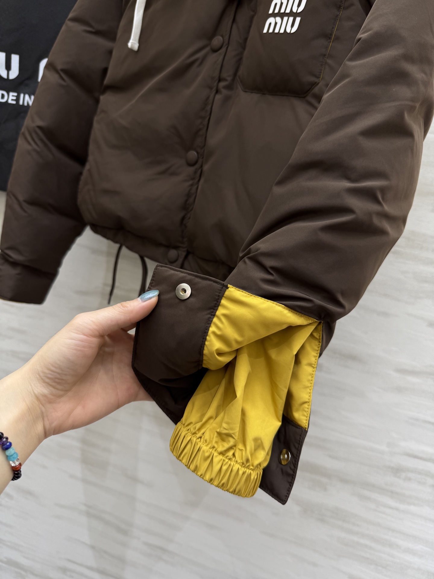 #Miumiu²⁵秋冬新款 假两件拼色面包羽绒服 深棕主调自带酷感 亮黄连帽撞色超吸睛 打破冬日沉闷 翻
