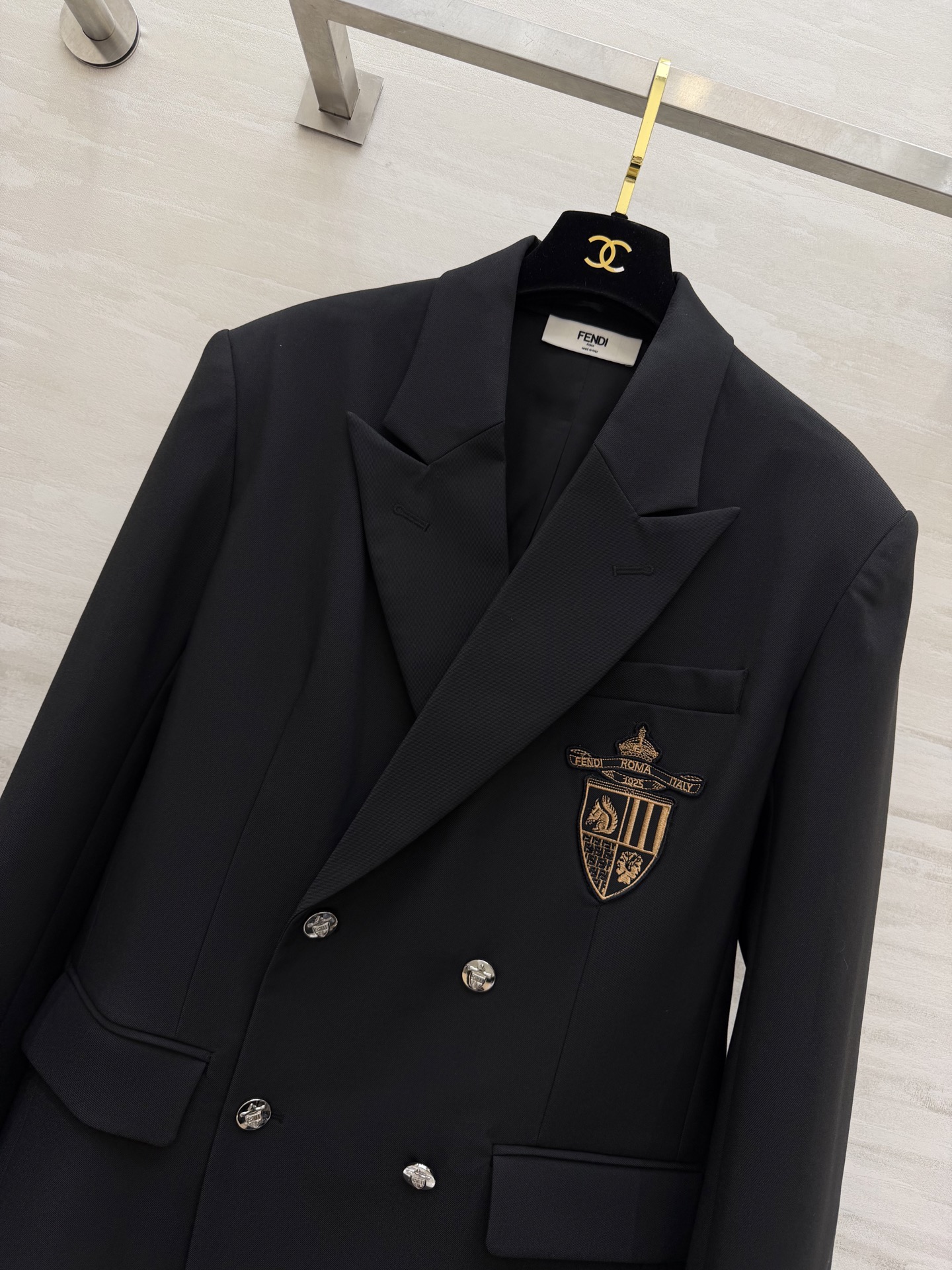 #FEND♡²⁶徽章西装 把贵族学院感穿在身上 经典黑色双排扣剪裁 挺括有型自带气场 胸口金色盾形徽章刺