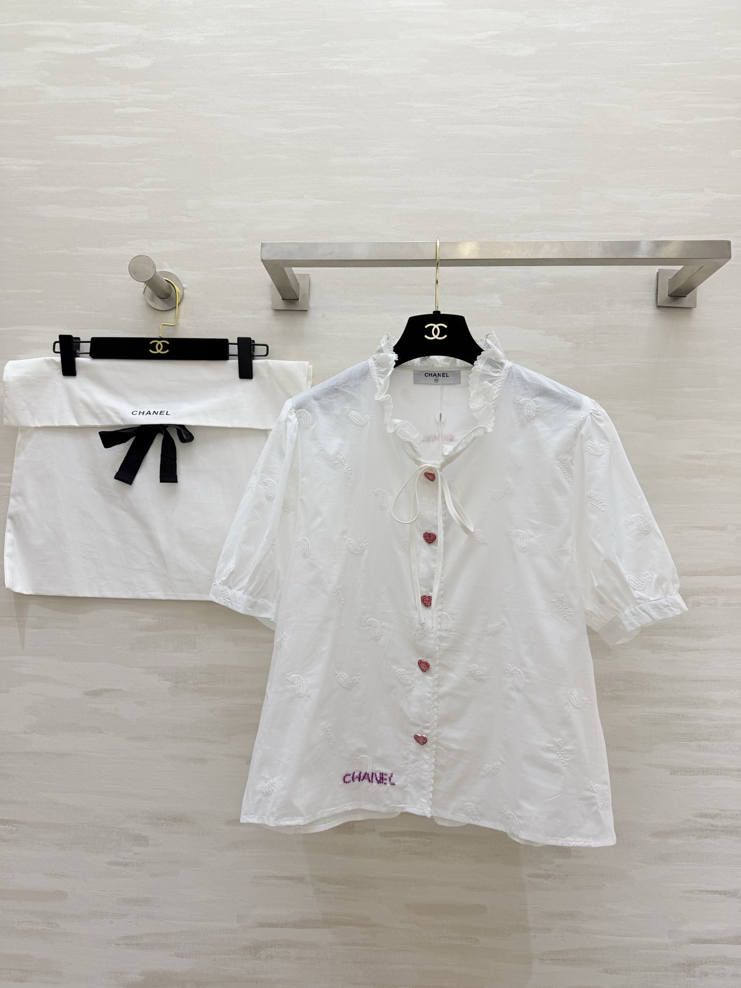 NO:778709,#Chane Love Button White Shirt Welds tenderness and romance to the body. The milky white pure cotton fabric has a sense of transparency. All-over cashew flower embroidery. The details are full of exquisiteness. Fungus-edged neckline. Pink love diamond buttons. Sweet but not greasy. Girly feeling. Puff sleeve design hides the flesh and makes the body slimmer. It becomes a right-angled shoulder in seconds. Logo letter embroidery on the hem is low-key and noble. High-quality customization.  Available now, size 36/38/40 (size 36, shoulder width 38, bust 104, length 57), Chanel-clothing, chanel, chanel, shirts,19860909#Chane爱心扣白衬衫 把温柔与浪漫焊在身上奶白色纯棉面料自带通透感 满幅腰果花刺绣 细节里藏满精致 木耳边系带领口 粉色爱心钻扣 甜而不腻 少女感直接拉满 泡泡袖设计藏肉显瘦 秒变直角肩 下摆logo字母刺绣 低调显贵 高品质定制 现货首发size36/38/40（36码肩宽38,胸围104,衣长57）,香奈儿-服装,chanel,chanel,shirts,,Women's clothing