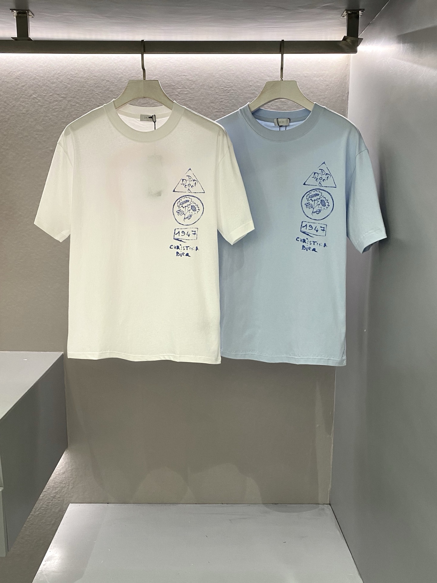 NO:152356,2025 Spring and Summer Di*r And Hylton Nel Printed Short-Sleeve T-shirts The Morse Code in Time Wrinkles, a new and fashionable eye-catching T-shirt. Classic micro-loose straight-cut cut creates a unique styling charm. Customer-supplied long velvet fine-branched cotton fabric, high-density woven craftsmanship makes the texture lighter, light, soft, tight and comfortable like cotton woven. The new Di*r And Hylton Nel pattern print adds ingenuity. The seemingly careless ink marks are actually the blessing of nanotechnology. It seems to be transformed in time and space with a vicissitudes of retro fading texture. The micro OS cut outlines the perfect temperament, reflecting the perfect grasp of sports and casual accents, and the deconstruction of neoclassicalism! Men and women are the same Color: White/Blue Size: S/M/L/XL/XXL Data  S: Bust 104cm-shoulder width 49cm-length 69cm-sleeve length 22cm M: Bust 108cm-shoulder width 50cm-length 71cm-sleeve length 23cm L: Bust 112cm-shoulder width 51cm-length 73cm-sleeve length 24cm XL: Bust 116cm-shoulder width 52cm-length 75cm-sleeve length 25cm XXL: Bust 120cm-shoulder width 53cm-length 77cm-sleeve length 26cm, T-shirt,tees,t-shirt,alexander wang198609092025春夏Di*r And Hylton Nel印花标识短袖T恤 时间褶皱里的摩斯密码,新时尚吸睛款T恤.经典微宽松直筒裁剪铸就独特造型魅力. 客供长绒细支棉面料,高密度机织工艺让质感更轻盈,如棉絮般轻盈柔软紧致舒适. 全新Di*r And Hylton Nel图案印花平添匠心.看似漫不经心的晕染墨迹实则是纳米工艺的加持.仿佛在时空中蜕变以沧桑复古褪色质感呈现亮相. 微OS型裁勾勒极富摩登气质,体现运动休闲腔调的完美拿捏,新古典主义解构! 男女同款 颜色:白色/蓝色 尺码:S/M/L/XL/XXL 数据 S码:胸围104cm-肩宽49cm-衣长69cm-袖长22cm M码:胸围108cm-肩宽50cm-衣长71cm-袖长23cm L码:胸围112cm-肩宽51cm-衣长73cm-袖长24cm XL码:胸围116cm-肩宽52cm-衣长75cm-袖长25cm XXL码:胸围120cm-肩宽53cm-衣长77cm-袖长26cm,,T-shirt,tees，t-shirt,alexander wang,Men's clothing