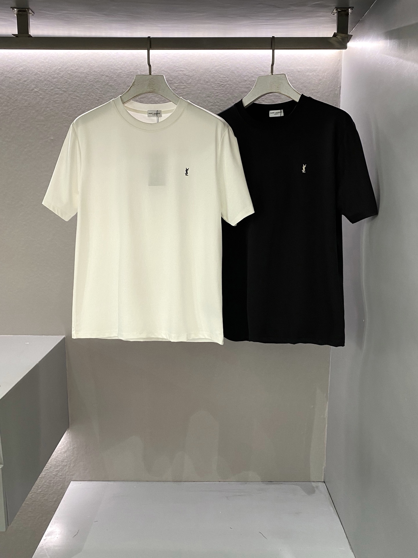 NO:414734,2025 Spring and Summer Sai*t Lau*ent embroidered logo short-sleeved T-shirt casual and fashionable style, classic fashion sense comes with the times, always attracting attention with a different posture. Customer-supplied fiber-friendly Piquet pore cotton fabric, which can be called 'breathable fabric'. The craft knitted quilting design makes the feel extremely smooth and delicate, without any roughness, making the body more comfortable and breathable. Chest embroidery Y*L brand logo sewn, rigorous and detailed, unambiguous, full of three-dimensional sense, class and quality can be seen by all... Men and women same style Color: Black/White Size: XS/S/M/L Data XS: Bust 104cm-Shoulder width 44cm-Length 69cm-Sleeve length 24cm S: Bust 108cm-Shoulder width 45cm-Sleeve length 71cm-Sleeve length 25cm  M size: bust 112cm-shoulder width 46cm-cloth 72cm-sleeve length 26cm L size: bust 116cm-shoulder width 47cm-cloth 73cm-sleeve length 27cm, T-shirt,tees,t-shirt,alexander wang198609092025春夏Sai*t Lau*ent 刺绣标识短袖T恤 休闲时尚通勤款,经典的时髦感与时俱来,时刻以别样姿态引人注目. 客供纤维环保Piquet气孔棉面料,堪称“会呼吸的面料”,工艺针织绗缝设计让手感极为顺滑细腻,无任何粗糙感,着身更为舒爽透气. 胸口刺绣Y*L品牌标识缝制,严谨细致不含糊,立体感十足,档次感及品质感可有目共睹…… 男女同款 颜色:黑色/白色 尺码:XS/S/M/L 数据 XS码:胸围104cm-肩宽44cm-衣长69cm-袖长24cm S码:胸围108cm-肩宽45cm-衣长71cm-袖长25cm M码:胸围112cm-肩宽46cm-衣长72cm-袖长26cm L码:胸围116cm-肩宽47cm-衣长73cm-袖长27cm,,T-shirt,tees，t-shirt,alexander wang,Men's clothing