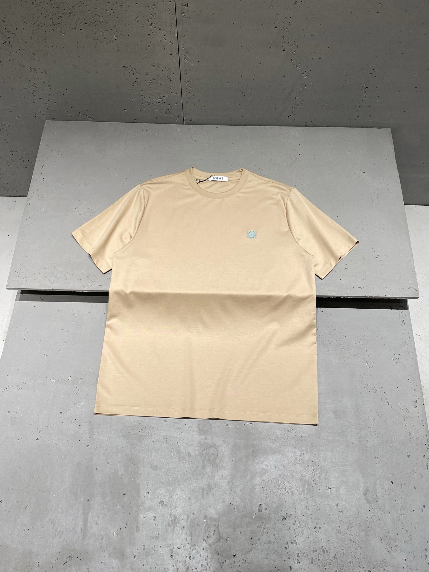 NO:855999,2026 Spring and Summer Lo*we Anagram embroidered logo short-sleeved T-shirt. The latest fashion temperament will infinitely extend the charm of fashion to the unique charm. Worsted plain woven cotton is designed and manufactured using imported machine spinning. The unique and innovative design is characterized by a more delicate woven cotton surface without any scattered flaws. It is breathable and comfortable to wear and has a soft and delicate feel. New color matching Anagram  The logo is even more outstanding. The machine embroidery design using imported thousands of needles makes the embroidery logo more meticulous, and the strong three-dimensional effect creates a new concept. Same style for men and women. Color: Milk tea Size: XS/S/M/L Data  M code: Bust 112cm - Shoulder width 46cm - Clothes length 74cm - Sleeve length 26cm L code: Bust 116cm - Shoulder width 47cm - Clothes length 76cm - Sleeve length 27cm, T-shirt, tees, t-shirt,198609092026春夏Lo*we Anagram刺绣标识短袖T恤 最新的时尚气质将魅力无限延伸时装的别样韵味. 精纺平织棉,采用进口机纺织造设计而成.独具创新的设计,特点在于织造棉面更为细腻无任何零散瑕疵,着身透气舒适,手感柔软细腻. 全新配色Anagram Logo更为出色,采用进口万针的机绣工艺设计让绣标更为缜密无间,立体感超强成就破茧而出的新概念. 男女同款 颜色:奶茶色 尺码:XS/S/M/L 数据 XS码:胸围106cm-肩宽44cm-衣长70cm-袖长24cm S码:胸围108cm-肩宽45cm-衣长72cm-袖长25cm M码:胸围112cm-肩宽46cm-衣长74cm-袖长26cm L码:胸围116cm-肩宽47cm-衣长76cm-袖长27cm,,T-shirt,tees，t-shirt,,Men's clothing