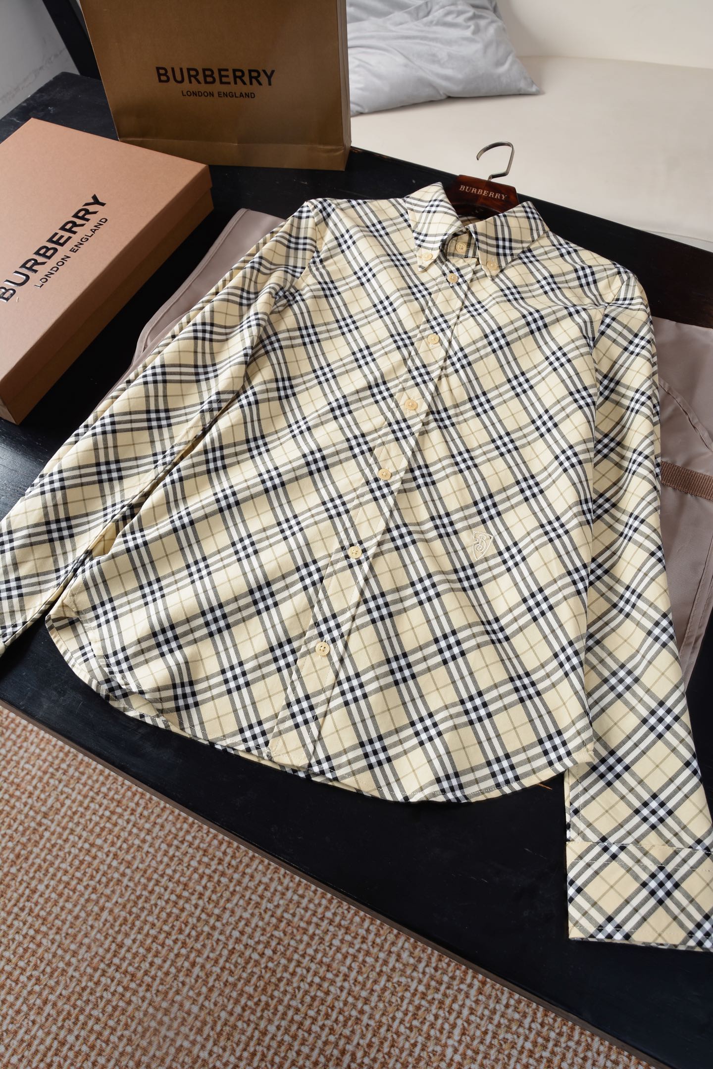 NO:782300,'Women's slim-fit plaid cotton shirt (-with full package), a modern translation of equestrian genes, ZG synchronization, 900.00 | British poetry woven with Italian warp and weft. When the knight's badge turns into a code word on the lapel, and when the century-old plaid becomes a flowing armor, this shirt is an elegant game between the gentleman's spirit and female power. 'Renaissance of fabric twill fabric' -  Italian worsted washed cotton twill, based on 14-micron ultra-long-staple cotton, undergoes a 48-hour enzyme washing process. It feels as smooth as the second layer of skin, and its wrinkle resistance is increased by 60. There is no need to compromise on laziness and dignity; -  Burberry's signature plaid is woven with 72-needle high-density jacquard, with more than 220 yarns interwoven in warp and weft per inch. It has a matte texture like parchment and ancient books in the sun, paying tribute to the brand's first generation checkerboard pattern code in 1901. 'Micro narrative of the aristocratic lineage of accessories' -  Natural mother-of-pearl buttons, a single selected piece of deep-sea mother-of-pearl with a diameter of 18mm, has been polished by 7 steps by hand, giving off an iridescent halo like morning mist, and the snapping sound is as crisp as the winding of an antique pocket watch; - B-shaped shield embroidery, using the mirror embroidery method inherited by the British Royal Embroidery Workshop, 0.1mm Japanese glitter embroidery thread outlines the 1902 EKD knight logo, and 100,000 stitches build a 3mm three-dimensional relief. Touching it with your fingertips is like touching the pattern of a medal.  'A Tailor's Ode to the Apennine Peninsula in Craftsmanship' 1. The draping revolution. Milanese patternmakers use architectural thinking to deconstruct shirts, splicing 16 curved pieces, and hiding 3cm of dynamic margin in the slim silhouette; 2 The patented technology of Vicenza, an Italian water washing plant, uses red wine yeast + volcanic mineral mud for distressing, giving new clothes a warm and timeless feel after ten years of wearing. 'The geometric revolution of body curves' -  The short model has intelligent proportions, and the curved hem is cut 2cm above the hip bone. Pair it with high-waisted bottoms to instantly reconstruct the 3:7 golden figure; - The chivalric cut shoulder line is retracted by 0.8cm, and the armholes are deepened by 1.5cm, showing a dynamic elegance like an equestrian suit when you raise your hands; - The mystery of the single-button cuffs, the mother-of-pearl buttons with a diameter of 14mm can be slid and adjusted, and the sexy scale of 21cm from the wrist to the elbow is naturally exposed when the sleeves are rolled up lazily.  When the knight's war horse logo looms on the hem, and when the mother-of-pearl buttons reflect rainbow light on the conference table - you are not wearing a shirt, but a fierce horse tamed with cotton thread, transforming the Edwardian knight's pride into the tenderness of the contemporary city. Sizes UK4-UK12 (slim fit recommended daily size) Dynamic and elegant; -  The secret of the single-button cuffs is that the mother-of-pearl buttons with a diameter of 14mm can be slid and adjusted. When the sleeves are lazily rolled up, the sexy scale of 21cm from the wrist to the elbow is naturally revealed.  When the knight's war horse logo looms on the hem, and when the mother-of-pearl buttons reflect rainbow light on the conference table - you are not wearing a shirt, but a fierce horse tamed with cotton thread, transforming the knightly pride of the Edwardian era into the gentleness of the contemporary city. Burberry - Clothing, burberry, shirts, sheepskin, gold,19860909「 女士修身格纹棉质衬衫（-配全套包装）马术基因的摩登转译,ZG同步,900.00 | 意大利经纬织就的英伦诗篇当骑士徽章化作衣襟上的暗语,当百年格纹成为流动的铠甲,这件衬衫,是绅士精神与女性力量的优雅博弈. 「面料斜纹织物的文艺复兴」 - 意大利精纺水洗棉质斜纹,以14微米超长绒棉为基底,经48小时酶素洗工艺,触感如第二层肌肤般柔滑,抗皱性提升60,慵懒与体面从此无需妥协；  - Burberry标志性格纹,以72针高密度提花织就,每英寸经纬交织超220根纱线,阳光下泛着羊皮纸古籍般的哑光质感,致敬1901年品牌初代棋盘纹密码.  「辅料贵族血统的微观叙事」 - 天然珍珠母贝纽扣,单颗精选直径18mm的深海贝母,经7道手工抛光,泛着晨雾般的虹彩晕光,扣合声如古董怀表上链般清脆；  - B字型盾牌刺绣,以英国皇家刺绣工坊传承的镜面绣法,0.1mm日本金葱绣线勾勒1902年EKD骑士徽标,十万针脚筑起3毫米立体浮雕,指尖抚过如触摸勋章纹路.  「工艺流程亚平宁半岛的裁缝咏叹」 1. 立体裁剪革命米兰版师以建筑思维解构衬衫,通过16片弧形裁片拼接,在修身廓形中暗藏3cm动态余量；  2意大利Vicenza洗水厂专利技术,以红酒酵母+火山矿物泥进行做旧处理,让新衣即拥有十年穿着的温润时光感.  「版型身体曲线的几何革命」 - 短款智慧比例,下摆弧形切割卡于胯骨上2cm,搭配高腰下装瞬间重构3:7黄金身段；  - 骑士精神剪裁肩线内收0.8cm,袖笼加深1.5cm,抬手时展现如马术服般的动态优雅；  - 单扣袖口的玄机,直径14mm的贝母纽扣可滑动调节,慵懒卷袖时自然展露手腕至肘部的21cm性感刻度.  当骑士战马徽标在下摆若隐若现,当珍珠母贝纽扣在会议桌上折射虹光——你穿着的不是一件衬衫,而是一匹用棉线驯服的烈马,将爱德华时代的骑士傲骨,化作当代都市的温柔. 尺码UK4-UK12（修身版型建议日常尺码） 动态优雅；  - 单扣袖口的玄机,直径14mm的贝母纽扣可滑动调节,慵懒卷袖时自然展露手腕至肘部的21cm性感刻度.  当骑士战马徽标在下摆若隐若现,当珍珠母贝纽扣在会议桌上折射虹光——你穿着的不是一件衬衫,而是一匹用棉线驯服的烈马,将爱德华时代的骑士傲骨,化作当代都市的温柔.,博柏利-服装,burberry,shirts,sheepskin,gold,,Women's clothing