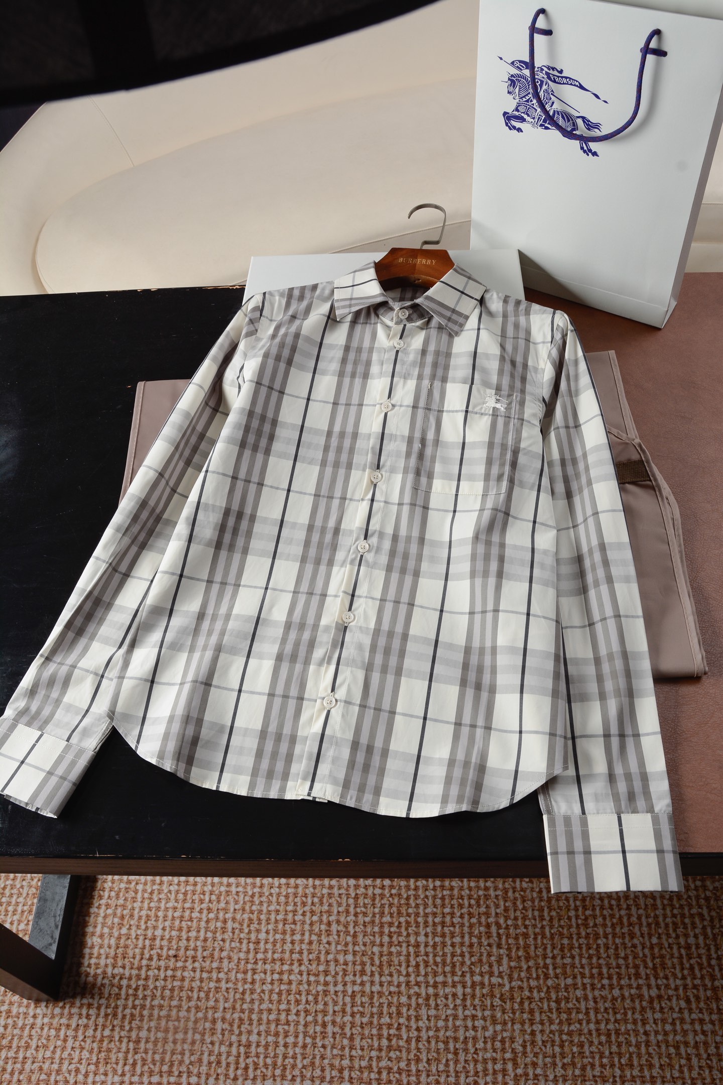 NO:782332,Women's regular-fit plaid cotton country shirt (-with complete package) is a modern translation of equestrian genes, | British poetry woven with Italian warp and weft. When the knight's emblem turns into a code word on the skirt, and when the century-old plaid becomes a flowing armor, this shirt is an elegant game between the gentleman's spirit and the power of women. It has a cool and relaxed feeling. A fresh outfit template for outdoor travel is here ~ Burberry's new cotton-colored cotton long-sleeved shirt is really amazing!  The Burberry plaid is low-key and classic, with a regular fit that is not flattering on the figure, and a gentle filter on the back of the upper body. The equestrian knight logo embroidery on the patch pocket adds a sense of sophistication. The soft cotton fabric is breathable and skin-friendly, so you won’t get sweaty even if you run wild outdoors. Pair the lower body with universal jeans, which is simple and casual, and can easily create a fresh atmosphere!  Shirt, made of Italian worsted cotton twill fabric, decorated with Burberry check. Regular fit, patch pockets embellished with EKD embroidery. – Button closure – Pointed collar – Front chest patch pocket – Single-button cuffs – Pockets embroidered with EKD – Curved hem – Regular fit, standard size, please choose your normal size. 'Renaissance of fabric twill fabric' -  Italian worsted washed cotton twill, based on 14-micron ultra-long-staple cotton, undergoes a 48-hour enzyme washing process. It feels as smooth as the second layer of skin, and its wrinkle resistance is increased by 60. There is no need to compromise on laziness and dignity; -  Burberry's signature plaid is woven with 72-needle high-density jacquard, with more than 220 yarns interwoven in warp and weft per inch. It has a matte texture like parchment and ancient books in the sun, paying tribute to the brand's first generation checkerboard pattern code in 1901. 'Micro narrative of the aristocratic lineage of accessories' -  Natural mother-of-pearl buttons, a single piece of deep-sea mother-of-pearl with a diameter of 18mm, has been polished by 7 steps by hand, with an iridescent halo like morning mist, and the snapping sound is as crisp as the winding of an antique pocket watch; - Knight war horse embroidery, using the mirror embroidery method inherited by the British Royal Embroidery Workshop, 0.1mm Japanese glitter embroidery thread outlines the 1902 EKD knight logo, and 100,000 stitches build a 3mm three-dimensional relief. Fingertips stroke it like touching the pattern of a medal.  Sizes UK4-UK12 (recommended daily size), Burberry-clothing, burberry, jeans, shirts, sheepskin,19860909女士常规版型格纹棉质村衫（-配全套包装）马术基因的摩登转译,| 意大利经纬织就的英伦诗篇当骑士徽章化作衣襟上的暗语,当百年格纹成为流动的铠甲,这件衬衫,是绅士精神与女性力量的优雅博弈. 自带清冷松弛感 户外出游的清新穿搭模板来啦～Burberry 新款的棉布色棉质长袖衬衫真的太绝！Burberry 格纹低调又经典,常规版型不挑身材,上身后自带温柔滤镜.贴袋处的马术骑士徽标刺绣,精致感拉满.柔软棉质面料透气叉亲肤,户外暴走也不会闷汗.下身搭配万能牛仔裤,简约又随性,轻松拿捏清新氛围！ 衬衫,选用意大利精纺棉质斜纹面料打造,装饰 Burberry 格纹.呈现常规版型,贴袋点缀马术骑士徽标（EKD）刺绣.– 纽扣开合– 尖领 – 前胸贴袋– 单扣式袖口– 口袋饰有马术骑士徽标（EKD）刺绣– 弧形衣摆– 常规版型,尺码标准,请选择平时正常尺码. 「面料斜纹织物的文艺复兴」 - 意大利精纺水洗棉质斜纹,以14微米超长绒棉为基底,经48小时酶素洗工艺,触感如第二层肌肤般柔滑,抗皱性提升60,慵懒与体面从此无需妥协；  - Burberry标志性格纹,以72针高密度提花织就,每英寸经纬交织超220根纱线,阳光下泛着羊皮纸古籍般的哑光质感,致敬1901年品牌初代棋盘纹密码.  「辅料贵族血统的微观叙事」 - 天然珍珠母贝纽扣,单颗精选直径18mm的深海贝母,经7道手工抛光,泛着晨雾般的虹彩晕光,扣合声如古董怀表上链般清脆；  - 骑士战马刺绣,以英国皇家刺绣工坊传承的镜面绣法,0.1mm日本金葱绣线勾勒1902年EKD骑士徽标,十万针脚筑起3毫米立体浮雕,指尖抚过如触摸勋章纹路.  尺码UK4-UK12（版型建议日常尺码）,博柏利-服装,burberry,jeans,shirts,sheepskin,,Women's clothing