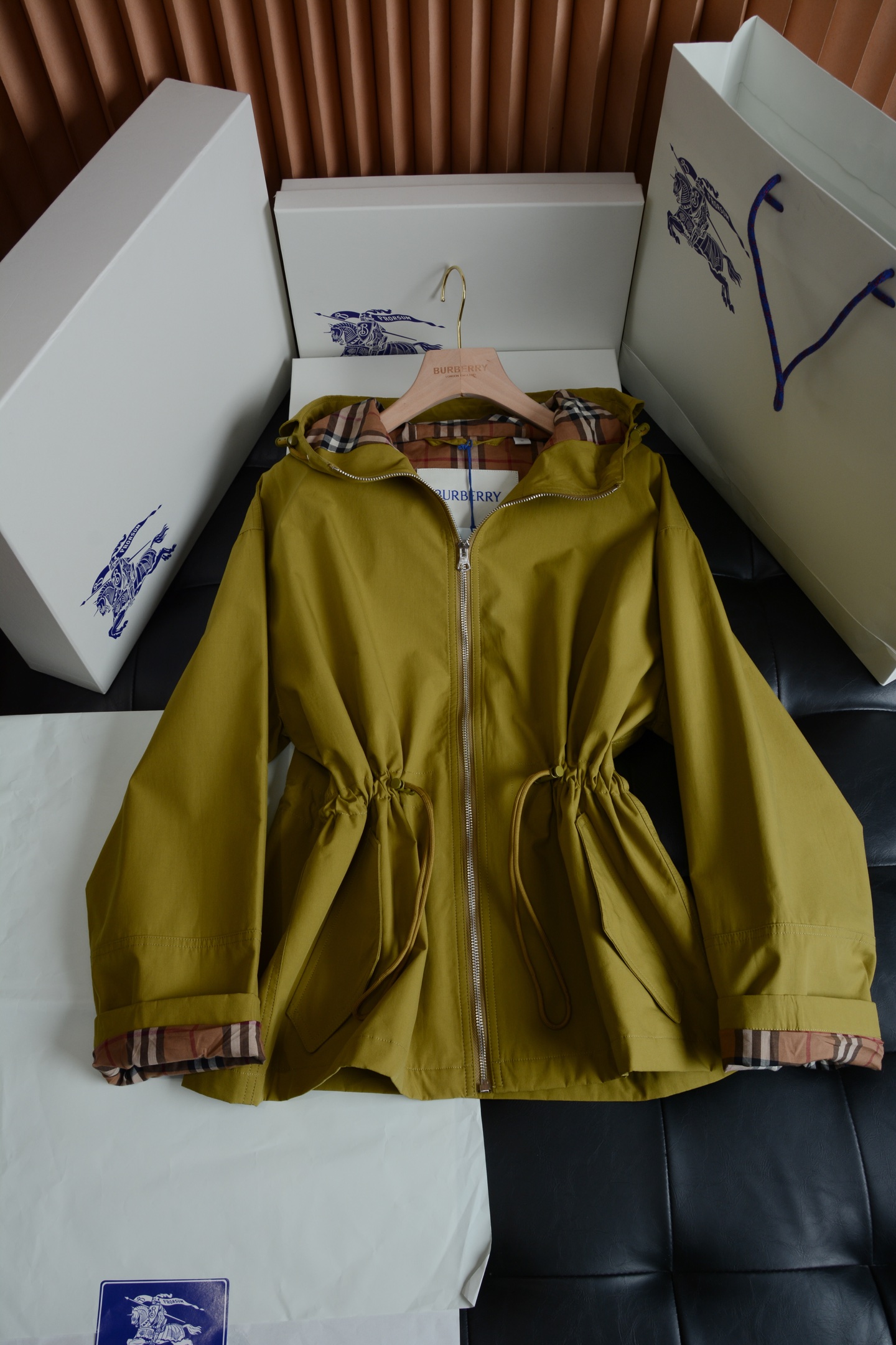 NO:786944,Military green hardware details · Low-key sophistication  The hardware accessories of the entire jacket have the right balance of practicality and brand texture. The main zipper uses a brand-customized metal zipper, which is smooth and not stuck. The zipper puller has the brand logo. The matte metal texture matches the soft tones of the body very well. It is low-key and unobtrusive, and the damping feeling of the pull is also very delicate. The drawstring waistband and the brim of the hat are adjusted in the same color drawstring, and matched with a metal rope buckle, you can easily adjust the tightness and create a comfortable fit.  It can create different dressing effects, and can echo the overall style in details, which is practical and exquisite. The inner details can be seen by opening the hood and seeing the iconic classic plaid lining, which is one of the most recognizable elements of BURBERRY. The contrasting plaid pattern of light carmine red and military green forms a low-key contrast with the solid color body. When the zipper is unzipped or worn open, the lining is inadvertently exposed, which instantly highlights the brand style.  Fabric texture · Comfortable and functional  The jacket is made of cotton blended fabric, which combines the neatness and stiffness of a windbreaker with the comfort of daily wear. The fabric has been treated with a special process and has a delicate matte texture. It feels soft and skin-friendly, but has a stiffness that prevents the upper body from being slumped and shapeless. It is also windproof and water-repellent, making it stress-free to deal with changing weather. The fabric is resistant to  It has excellent wrinkle resistance, is not prone to wrinkles in daily wear, and is easy to take care of. It comes in two colors: light carmine red and army green. The fabric is evenly colored, has a high-end texture, and has no cheap reflective feel. The upper body comes with a soft high-end filter. The plaid fabric inside is skin-friendly and breathable, and there is no discomfort when worn next to the skin. It will not be stuffy even when worn alone in spring and autumn.  Style tailoring · Relaxed silhouette that hides flesh and makes you look slimmer  The design of the short hooded windbreaker perfectly balances leisure and elegance, and is very friendly to all body types. The overall shape is slightly loose and straight, not tight nor oversized. The upper body is neat and does not weigh down the body. It is extremely tolerant of the waist, abdomen and arms, and can easily hide the small flesh. The drawstring design at the waist is the finishing touch of the whole piece. The elasticity can be adjusted freely, which can create a high waistline and optimize the body.  The material proportions can also create a lazy and casual atmosphere, and you can switch between different dressing styles by retracting or retracting it. The hooded design has its own casual attributes. The hood is three-dimensional and not soft. It is equipped with an adjustable drawstring, which can not only prevent wind but also modify the face shape. The hem design, which is short in the front and long in the back, can well modify the crotch line. It can be easily matched with jeans, sports pants, and skirts, and can easily create an effortless British relaxed feeling.  This BURBERRY short windbreaker perfectly combines the brand's classic genes with modern daily wear. It can be easily held whether it is commuting, traveling or daily leisure. It is a versatile item in the wardrobe that will never go out of style. Details determine the quality. The fabric is waterproof inside and outside, original hardware, exquisite matching labels, and meticulous workmanship!  Dear BUR fans, the classic trench coat that has been passed down for generations is a style you don’t need to consider at all!  All old fans, go and interpret this style on your own!  All ready goods have been warehoused, looking forward to your wonderful combination!  ,Burberry-clothing,burberry,versace,skirts,jeans,jackets & coats,hats,19860909军绿色 五金细节 · 低调的精致感 整件外套的五金配件,把实用性和品牌质感拿捏得恰到好处.主拉链采用品牌定制的金属拉链,顺滑不卡顿,拉链头带有品牌标识,哑光金属质感和衣身柔和的色调适配度极高,低调不张扬,拉合的阻尼感也十分细腻.调节抽绳腰头和帽檐的同色系抽绳,搭配金属绳扣,既能轻松调整松紧度,打造不同的穿搭效果,又能在细节处呼应整体风格,实用又不失精致.内里细节翻开帽子就能看到标志性的经典格纹内衬,这是BURBERRY最具辨识度的元素之一,浅胭脂红与军绿的撞色格纹,和纯色衣身形成了低调的反差感,拉开拉链或敞开穿时,不经意露出的内里,瞬间点明品牌格调. 面料质感 · 舒适与机能兼具 外套采用棉质混纺面料打造,兼顾了风衣的利落挺括和日常穿着的舒适感.面料经过特殊工艺处理,自带细腻的哑光肌理感,触感柔软亲肤,却又自带挺括度,上身不会软塌无形,同时具备防风防泼水的特性,应对多变天气毫无压力.面料抗皱性优秀,日常穿着不易起皱,打理起来也很方便,浅胭脂红和军绿色两种配色,面料着色均匀,质感高级,没有廉价的反光感,上身自带柔和的高级滤镜.内里的格纹面料亲肤透气,贴肤穿着也毫无不适感,即使在春秋季单穿也不会闷热. 版型剪裁 · 藏肉显瘦的松弛廓形 短款连帽风衣的版型设计,完美平衡了休闲与优雅,对各种身材都十分友好.整体是微宽松直筒廓形,不紧绷也不过于oversize,上身利落不压个子,对腰腹和手臂的包容度极高,能轻松藏住小肉肉.腰部的抽绳设计是整件的点睛之笔,可自由调节松紧,既能打造出高腰线,优化身材比例,也能营造出慵懒随性的氛围感,收放之间,就能切换不同的穿搭风格.连帽的设计自带休闲属性,帽型立体不软塌,搭配可调节抽绳,既能防风又能修饰脸型,前短后长的衣摆设计,能很好地修饰胯部线条,搭配牛仔裤、运动裤、半身裙都能轻松驾驭,轻松打造不费力的英伦松弛感. 这件BURBERRY短款风衣,把品牌的经典基因和现代日常穿搭完美融合,无论是通勤、出游还是日常休闲,都能轻松hold住,是衣柜里永远不会过时的百搭单品. 细节决定品质面料内外防水,原版五金,精致对版衣标,细致车工！各位BUR的老粉,传承几代的经典风衣完全不需要考虑的款式！各位老粉自行去演绎此款吧！现货均已入仓,期待你们的精彩搭配！,博柏利-服装,burberry,versace,skirts,jeans,jackets & coats,hats,,Women's clothing