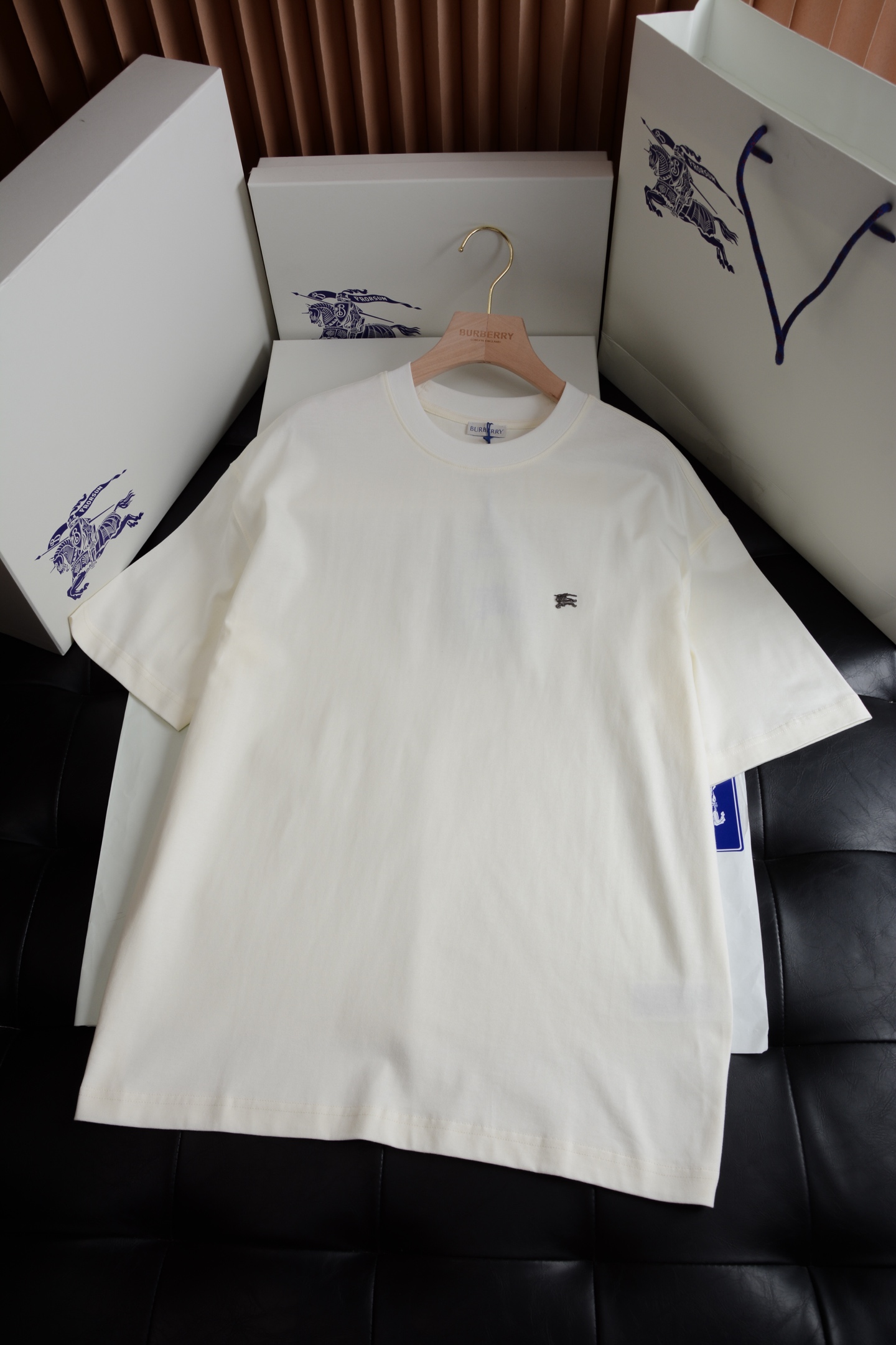 NO:786967,The T-shirt is made of medium-thick plain cotton fabric and has a slim fit. The round-neck style is low-key embellished with the retro-looking metal Equestrian Knight logo (EKD), echoing the protective armor material. The core design of this T-shirt is the finishing touch of the entire look. It abandons the regular arrangement of embroidery patterns and uses exquisite and compact customized hardware knights and horses, which is simple but not simple!  This design not only retains the brand's iconic elements, but also injects a sense of modern art and a relaxed atmosphere, which perfectly matches the vitality and freshness of early spring. The wearing experience is made of light plain cotton fabric to ensure the comfort and breathability of the skin. The casual version and round neck design set the overall relaxed and lazy tone, which is the key to enhance the fashion style. Burberry-clothing, tees, t-shirt,19860909T 恤衫,选用中厚平织棉面料打造,呈现修身版型.圆领款式,低调点缀复古感金属马术骑士徽标（EKD）,呼应防护盔甲材质. 设计核心这款T恤是整套造型的点睛之笔.它摒弃了刺绣图案规整排列,采用精致小巧定制五金骑士战马,简约而不简单！这种设计既保留了品牌的标志性元素,又注入了现代艺术感与轻松氛国,完美契合早春的活力与清新. 穿着体验采用轻盈平织棉面料,保证贴肤的舒适性与透气性.休闲版型与圆领设计奠定了整体轻松慵懒的基调,是提升造型时尚度的关键内搭.,博柏利-服装,tees，t-shirt,,Women's clothing