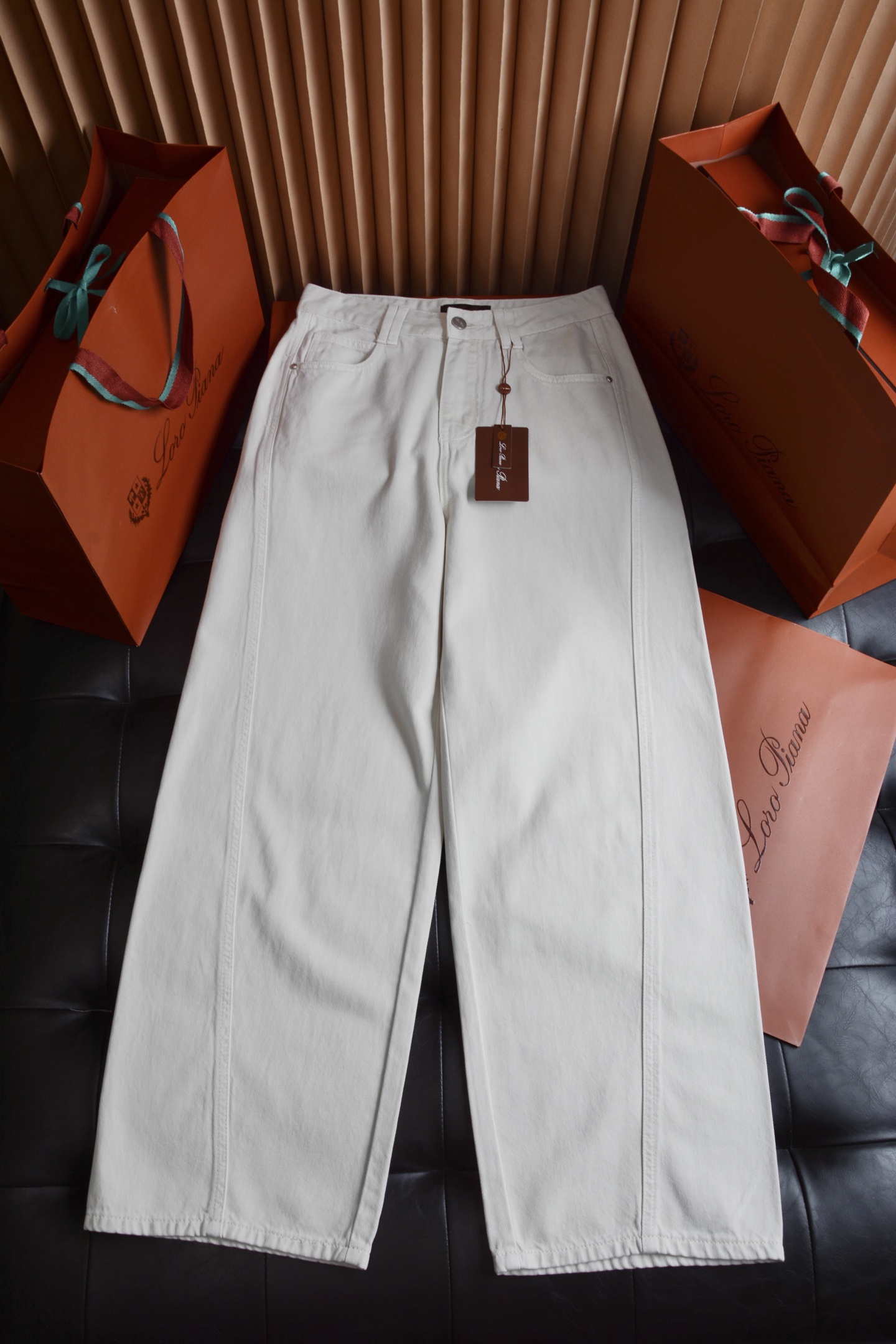NO:786954,Hardware accessories details  The main buckle is made of matte white copper, with the LP brand logo embossed on the surface. It is wear-resistant and not easy to oxidize, and opens and closes smoothly without jamming. Accessories such as side seam studs and zipper pullers have been treated with anti-corrosion and blend perfectly with the white denim background without any obtrusive metal reflection, showing a high-end texture. The leather tags on the waistband and pockets are made of the brand's iconic calf leather, and the stencil embossing process is clear and three-dimensional. Every detail tells the rigor of Italian craftsmen., women's clothing, loro  piana,19860909五金辅料细节 主扣采用哑光白铜材质,表面压印LP品牌徽标,耐磨不易氧化,开合顺滑不卡顿.侧缝撞钉、拉链头等配件均经过抗腐蚀处理,与白色牛仔底色完美融合,无突兀金属反光,尽显高级质感.裤腰、口袋处的皮革吊牌为品牌标志性小牛角皮材质,钢印压花工艺清晰立体,每一处细节都在诉说着意大利匠人的严谨.,女装,loro piana,,Women's clothing