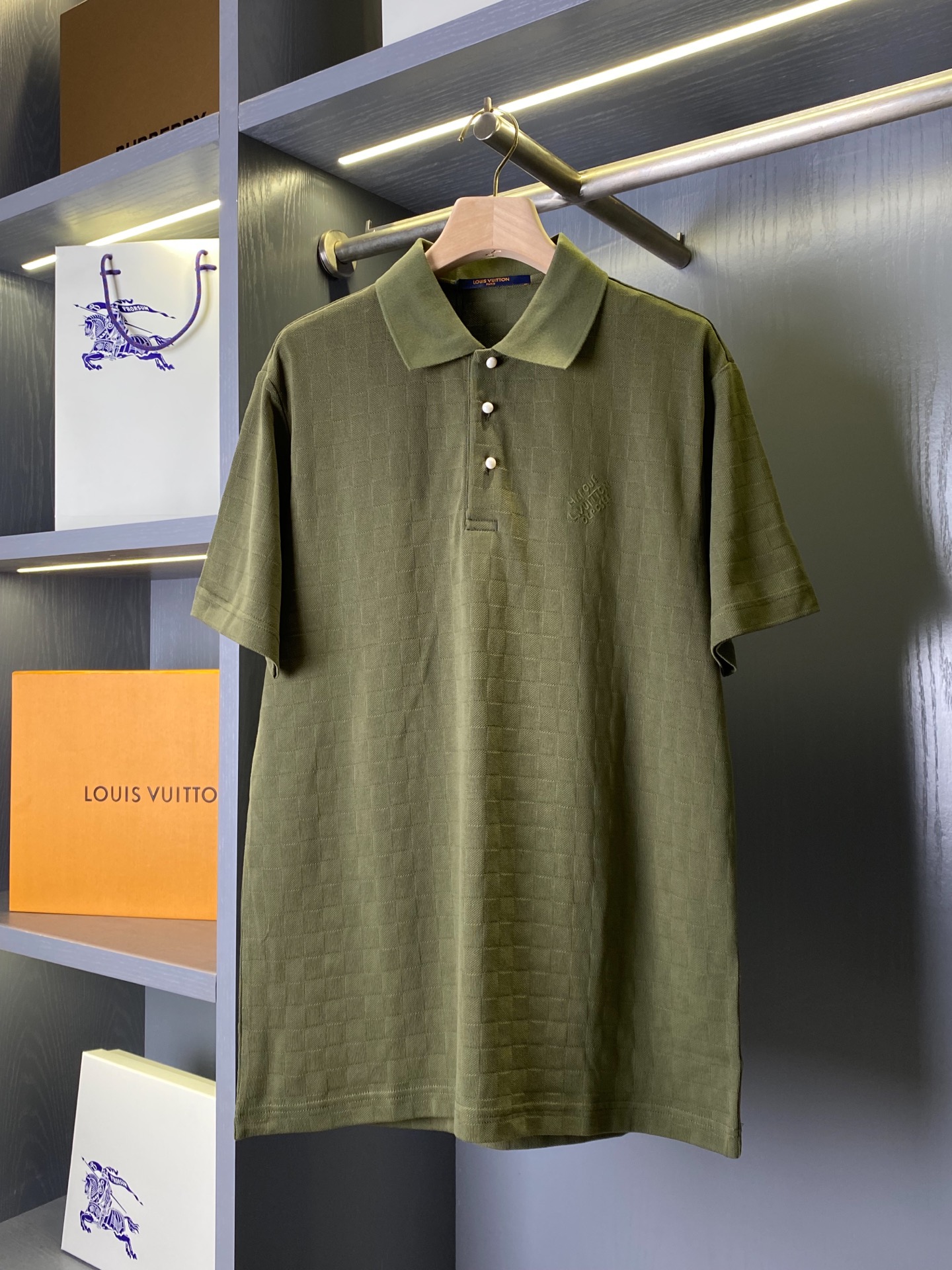 NO:786976,Product code 110010695832 LVDAMIER polo shirt (-comes with full set of carton packaging) LV dark pattern checkerboard Polo｜Low-key luxury, texture is king This LV black checkerboard Polo hides classics in the texture and uses details to highlight the style. The hardware, fabric and version are triple exquisite, making it easy to adapt to many scenes. The hardware details are warm and textured, hiding brand recognition.  The placket uses pearl white textured buttons, with a delicate pearlescent luster on the surface, which is gentle and non-glaring. It forms a soft contrast with the black body, low-key and noble. The fit of the buttons and placket is perfect, each one is smooth and fast, and there is no cheap stuck feeling. The embroidered logo on the left chest is hidden ingenuity, using low-key same-color craftsmanship to present the brand words, without exaggerated large logos, but conveying LV's exclusive texture in the details, restrained and high-end.  Fabric craftsmanship with dark texture, soft, waxy and breathable  The whole piece is made of high-density knitted pique fabric, with LV's iconic checkerboard dark pattern woven into the pure black background. It will show a looming checkered texture under the light and shadow, which is unobtrusive but highly recognizable. The fabric feels soft and skin-friendly, and has a stiffness. The upper body is not soft or clinging to the flesh. It has both breathability and drape. It is not sweaty when worn in summer, and it is not easy to deform or pill after being washed for a long time. The texture is online.  The cut is neat and loose, not flattering on the body shape  Adopting a classic slightly loose straight version, the shoulder line falls naturally, does not press the shoulders or collapses, and is friendly to various shoulder shapes; the Polo lapel is neatly cut, not easy to curl and deform, and is paired with a half-open placket, giving it a light business sophistication. The cuffs  It is trimmed with same-color ribbing as the hem. It has moderate elasticity and fits the body shape without being tight. The overall cut is clean and neat. The upper body can modify the body shape without appearing restrictive. Whether worn alone or layered, it can create a relaxed and high-end atmosphere.  This dark checkerboard Polo is an excellent choice to wear LV's classics into daily life. It is low-key and unobtrusive, but full of texture details. It can easily be used as a versatile texture in men's wardrobe. S-XL, Louis Vuitton-clothing, louis vuitton, louis vuitton,19860909商品编码110010695832 LVDAMIER 马球衫（-配全套纸盒包装）LV暗纹棋盘格Polo｜低调奢感,质感为王 这一件LV黑色棋盘格Polo,把经典藏进肌理,用细节彰显格调,五金、面料、版型三重考究,轻松适配多场景穿搭. 五金细节温润质感,暗藏品牌辨识度 门襟采用珍珠白质感纽扣,表面带有细腻珠光光泽,温润不刺眼,与黑色衣身形成柔和对比,低调又显贵.纽扣与门襟的贴合度严丝合缝,每一颗都顺滑好扣,没有廉价的卡顿感.左胸的刺绣标识暗藏巧思,以低调的同色系工艺呈现品牌字样,没有夸张的大logo,却在细节处传递LV的专属质感,内敛又高级. 面料工艺暗纹肌理,软糯透气 整件采用高密针织珠地面料,在纯黑底色上织入了LV标志性的棋盘格暗纹,在光影下会呈现出若隐若现的格纹肌理,不张扬却辨识度拉满.面料触感软糯亲肤,同时自带挺括度,上身不软塌、不贴肉,兼具透气性与垂坠感,夏天穿也不闷汗,久洗也不易变形、起球,质感在线. 版型剪裁利落松弛,不挑身形 采用经典的微宽松直筒版型,肩线自然落肩,不压肩也不垮塌,对各种肩型都很友好；Polo翻领剪裁利落,不易卷边变形,搭配半开襟门襟,自带轻商务的精致感.袖口与下摆采用同色系罗纹收边,弹性适中,贴合身形不紧绷,整体剪裁干净利落,上身既能修饰身形,又不会显得拘谨,无论是单穿还是内搭,都能穿出松弛又高级的氛围感. 这件暗纹棋盘格Polo,是把LV的经典穿进日常的绝佳选择,低调不张扬,却处处都是质感细节,轻松拿捏男士衣橱里的百搭质感担当. S-XL,路易威登-服装,louis vuitton,louis vuitton,,Women's clothing