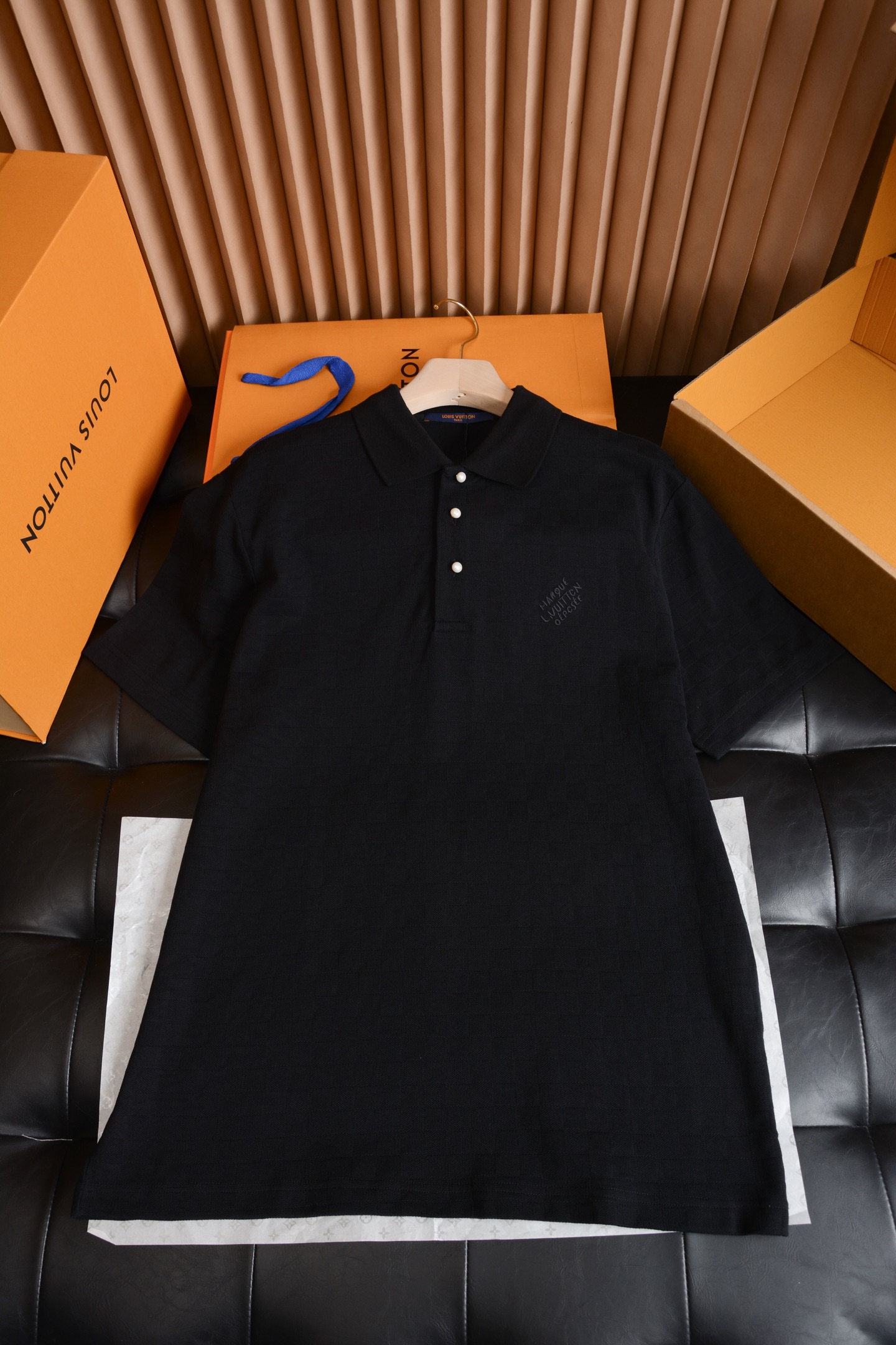 NO:786982,The hardware details have a warm texture and conceal brand recognition.  The placket uses pearl white textured buttons, with a delicate pearlescent luster on the surface, which is gentle and non-glaring. It forms a soft contrast with the black body, low-key and noble. The fit of the buttons and placket is perfect, each one is smooth and fast, and there is no cheap stuck feeling. The embroidered logo on the left chest is hidden ingenuity, using low-key same-color craftsmanship to present the brand words, without exaggerated large logos, but conveying LV's exclusive texture in the details, restrained and high-end.  Fabric craftsmanship with dark texture, soft, waxy and breathable  The whole piece is made of high-density knitted pique fabric, with LV's iconic checkerboard dark pattern woven into the pure black background. It will show a looming checkered texture under the light and shadow, which is unobtrusive but highly recognizable. The fabric feels soft and skin-friendly, and has a stiffness. The upper body is not soft or clinging to the flesh. It has both breathability and drape. It is not sweaty when worn in summer, and it is not easy to deform or pill after being washed for a long time. The texture is online.  The cut is neat and loose, not flattering on the body shape  Adopting a classic slightly loose straight version, the shoulder line falls naturally, does not press the shoulders or collapses, and is friendly to various shoulder shapes; the Polo lapel is neatly cut, not easy to curl and deform, and is paired with a half-open placket, giving it a light business sophistication. The cuffs  It is trimmed with same-color ribbing as the hem. It has moderate elasticity and fits the body shape without being tight. The overall cut is clean and neat. The upper body can modify the body shape without appearing restrictive. Whether worn alone or layered, it can create a relaxed and high-end atmosphere.  This dark checkerboard Polo is an excellent choice to wear LV’s classics into daily life. It is low-key and unobtrusive, but full of texture details. It can easily be used as a versatile texture in men’s wardrobe., Louis Vuitton-clothing, louis vuitton, louis vuitton,19860909五金细节温润质感,暗藏品牌辨识度 门襟采用珍珠白质感纽扣,表面带有细腻珠光光泽,温润不刺眼,与黑色衣身形成柔和对比,低调又显贵.纽扣与门襟的贴合度严丝合缝,每一颗都顺滑好扣,没有廉价的卡顿感.左胸的刺绣标识暗藏巧思,以低调的同色系工艺呈现品牌字样,没有夸张的大logo,却在细节处传递LV的专属质感,内敛又高级. 面料工艺暗纹肌理,软糯透气 整件采用高密针织珠地面料,在纯黑底色上织入了LV标志性的棋盘格暗纹,在光影下会呈现出若隐若现的格纹肌理,不张扬却辨识度拉满.面料触感软糯亲肤,同时自带挺括度,上身不软塌、不贴肉,兼具透气性与垂坠感,夏天穿也不闷汗,久洗也不易变形、起球,质感在线. 版型剪裁利落松弛,不挑身形 采用经典的微宽松直筒版型,肩线自然落肩,不压肩也不垮塌,对各种肩型都很友好；Polo翻领剪裁利落,不易卷边变形,搭配半开襟门襟,自带轻商务的精致感.袖口与下摆采用同色系罗纹收边,弹性适中,贴合身形不紧绷,整体剪裁干净利落,上身既能修饰身形,又不会显得拘谨,无论是单穿还是内搭,都能穿出松弛又高级的氛围感. 这件暗纹棋盘格Polo,是把LV的经典穿进日常的绝佳选择,低调不张扬,却处处都是质感细节,轻松拿捏男士衣橱里的百搭质感担当.,路易威登-服装,louis vuitton,louis vuitton,,Women's clothing