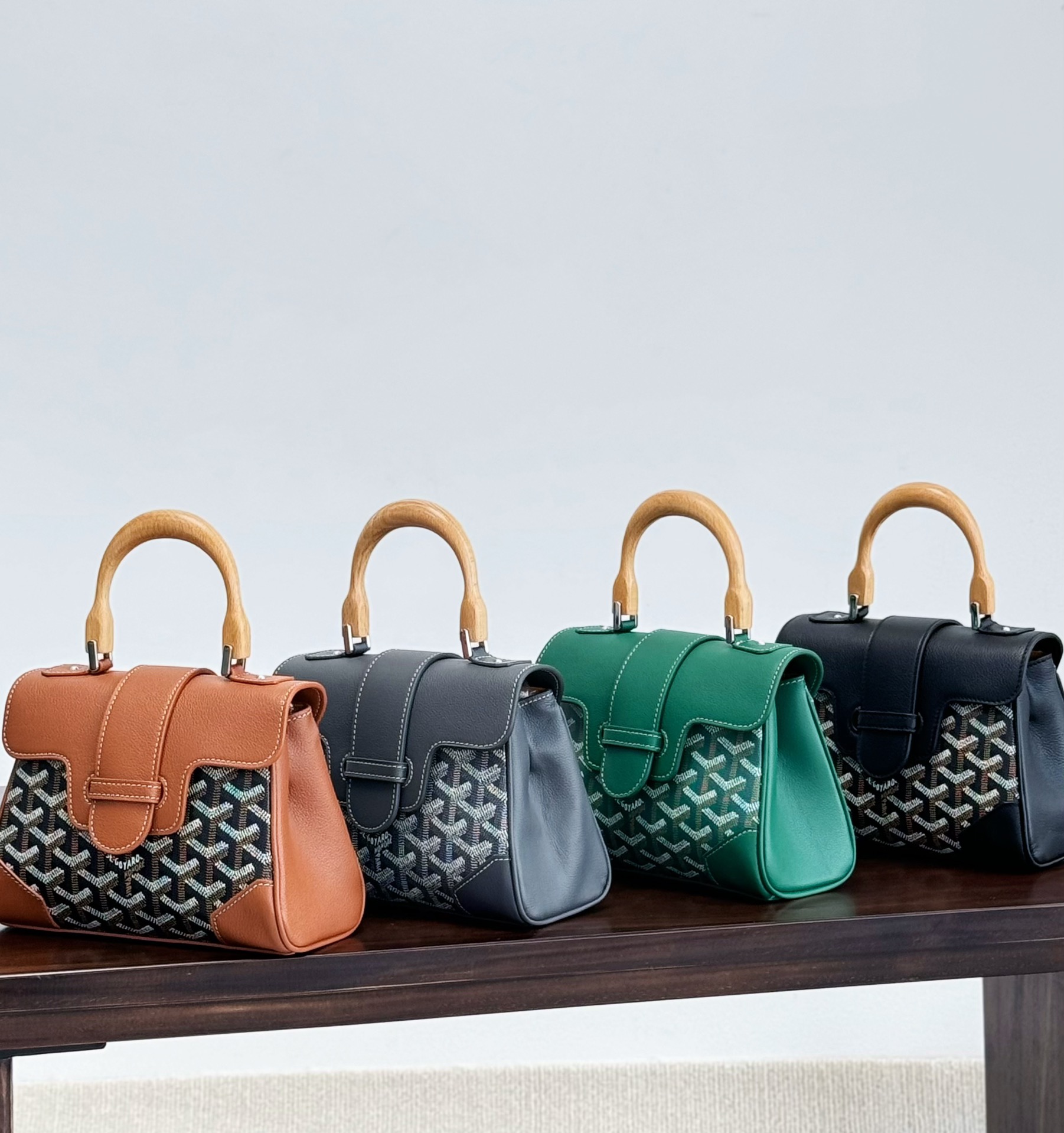 Original hardware and leather, easily pass customs and counters. Sweet or cool style~  
Goyard mini Saigon bag. Since our last launch of the Goyard mini tote, many have requested this Saigon bag. The wooden handle is uniquely attractive.  
This highly sought-after mini Saigon bag symbolizes love, elegance, and refinement. Low-key with perfect craftsmanship, it’s a charming vintage style that’s hard to resist.  
The wooden handle is a stylish highlight, adding romantic elegance. The shoulder strap is fully detachable, allowing it to be carried by the small wooden ring—super chic!  
Like the authentic, the wood grain on the ring is clear and smooth, treated with imported waterproof lacquer to prevent yellowing or moisture damage over time.  
The Saigon bag uses its printed logo sparingly, only under the flap. Leather covers the edges for durability and a refined finish.  
Size: 20*16*6 cm. Large capacity, versatile for all seasons. image 1
