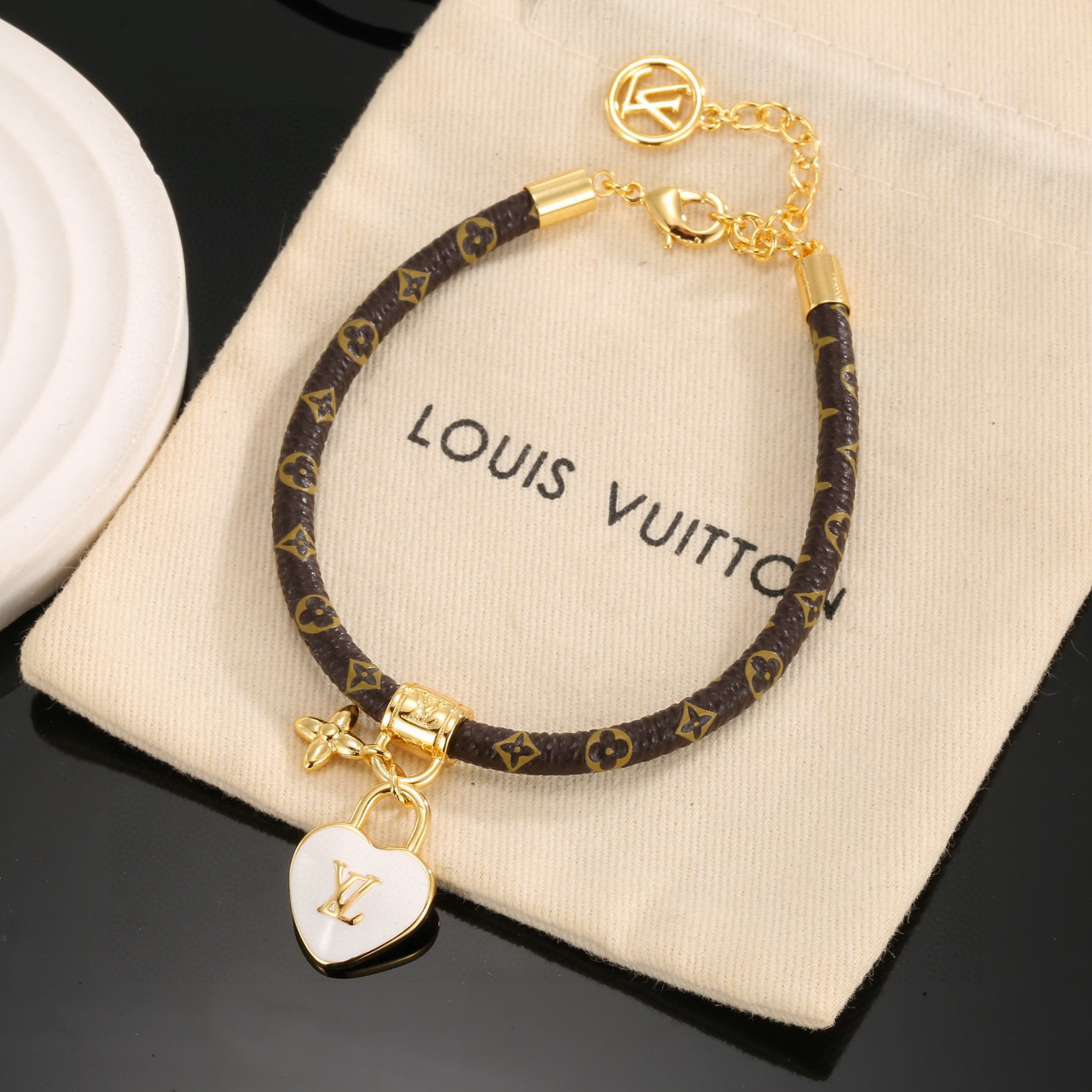  男女可戴 LV Circle 可逆手绳以标志性的单字帆布和金色金属树干螺柱为特征，向路易威登的历史致敬