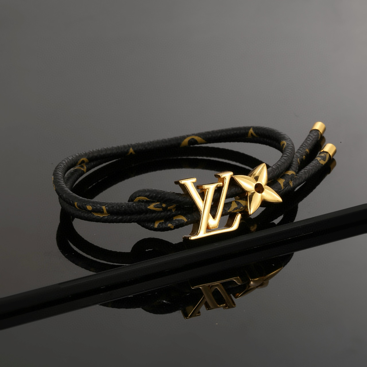  男女可戴 LV Circle 可逆手绳以标志性的单字帆布和金色金属树干螺柱为特征，向路易威登的历史致敬