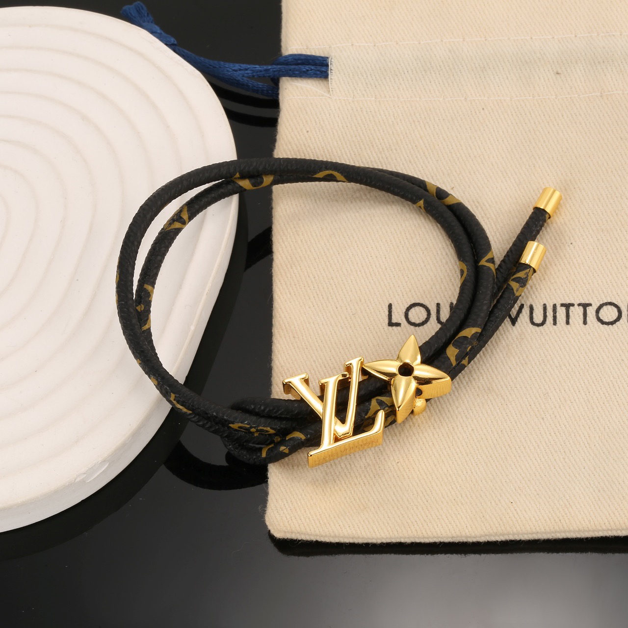 Louis Vuitton 男女可戴 LV Circle 可逆手绳以标志性的单字帆布和金色金属树干螺柱为特征