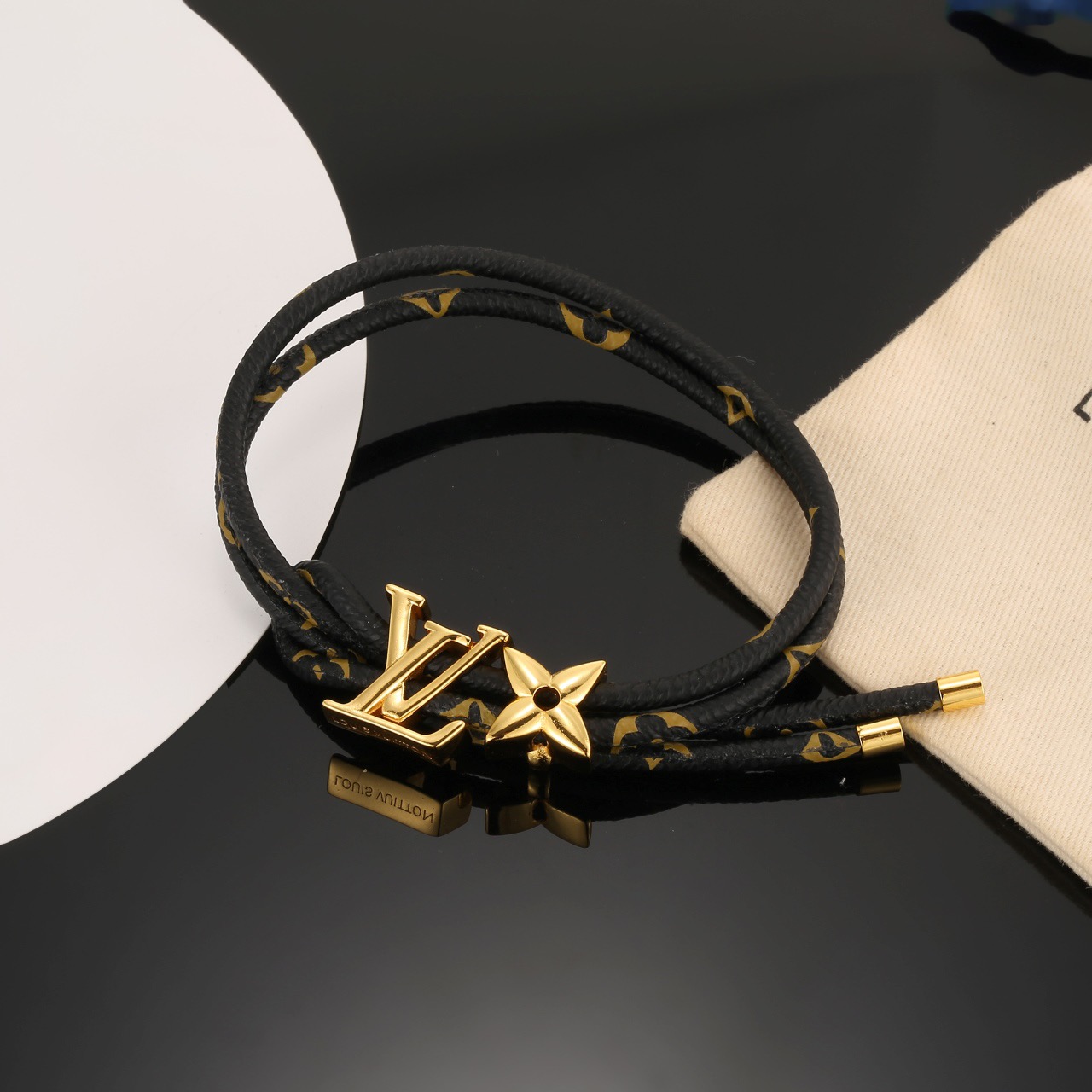 Louis Vuitton 男女可戴 LV Circle 可逆手绳以标志性的单字帆布和金色金属树干螺柱为特征
