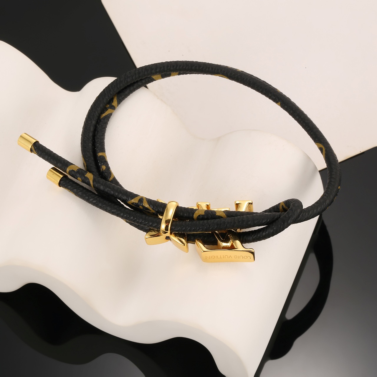 Louis Vuitton 男女可戴 LV Circle 可逆手绳以标志性的单字帆布和金色金属树干螺柱为特征
