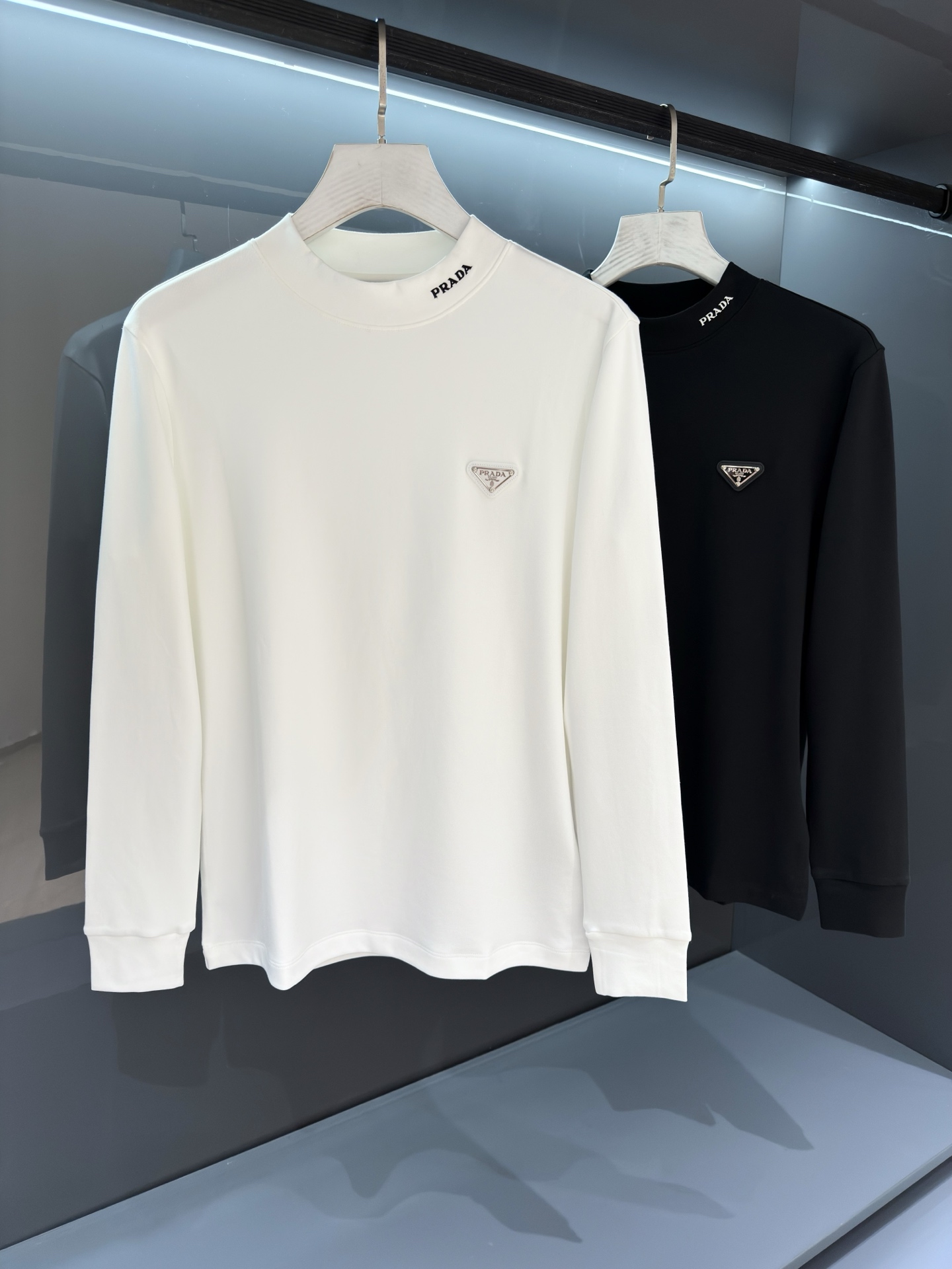NO:538806,[New Product] 2025 Autumn and Winter Pr*da Neck Embroidery Triangle Logo Long Sleeve T-shirt Base Shirt High-end Fabric!  The casual classic minimalist style comes from the new beauty of PD, with a slim design and tailoring. Knitted cotton fabric, an extraordinary texture experience, is known as the most suitable cotton fabric for autumn and winter, light and breathable, excellent comfort, soft and delicate and natural. The fixed-woven double-layer ribbed neckline design is designed with a flat and smooth matte not easy to deform. The chest patch Milano base logo is still the same, creating an alternative luxury and fashionable atmosphere. Color white/black Size S/M/L/XL/2XL S Shoulder width 42 bust 98 Long 64 Sleeve length 60, tees, t-shirt, alexander wang19860909【新品】2025秋冬Pr*da 领口刺绣 三角标识长袖T恤打底衫 高端面料 ！ 休闲的经典极简风格来自PD的新秀丽作,修身设计裁剪兼具个性时尚范儿. 针织棉面料,非同一般的质感体验,号称最适合秋冬的棉质面料,轻盈透气,舒适感极佳,柔软细腻更为自然. 定织型的双层罗纹领口设计,平整服贴不易变形.胸口贴布Milano基底标识依旧,营造出另类的奢华时尚气息. 颜色白色/黑色 尺码S/M/L/XL/2XL S肩宽42胸围98衣长64袖长60,,tees，t-shirt,alexander wang,Men's clothing