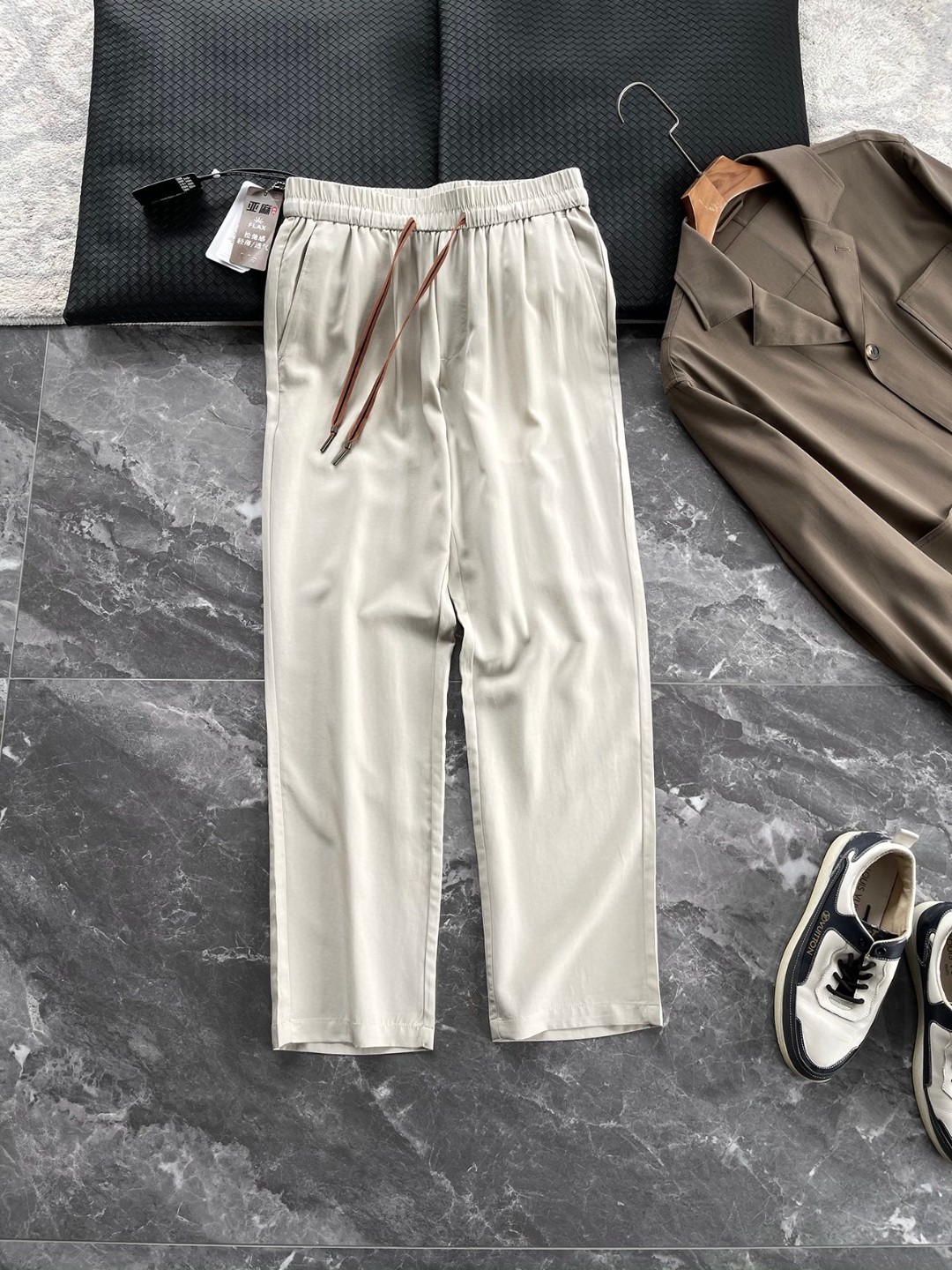 NO:137176,The source fabric supply is customer-supply. TencelTM Tiansi Laiser Ramie authoritative tag authorized rear pocket iconic 232 webbing embellishes thin, comfortable and skin-friendly drawstring elastic waist for men. A pair of casual straight trousers produced by trading company, a trustworthy trousers!  The fabric is woven with high-end components of 96.4 lyceler 3.6 ramie. The lyceler fiber has high strength and can still maintain a good shape after multiple washings, and it will last forever. At the same time, its excellent moisture absorption and breathability further improves the comfort of wearing, works synergistically with other fibers to achieve a perfect balance between comfort and quality. It gives trousers excellent clarity, and no matter what scenarios you wear, it can maintain a straight trouser line and not easily deform. Even if you walk for a long time or sit for a long time, it can maintain a neat appearance and show a capable temperament. Its wear resistance is also very good, and can withstand the friction of daily wear and accompany it for a long time. The ramie fiber has a strong moisture absorption ability and can quickly absorb sweat on the surface of the skin and emit it to keep it dry.  The waist is made of drawstring   elastic design, which is not only easy to put on and take off, but also can be freely adjusted according to personal needs, avoiding the restraint of the traditional waistband. The inner part is sewn with three-stitch five-line and edge-covering technology. The most commendable thing is the three-dimensional cutting and collection technique that continues along the direction of the insertion bag. The streamlined lines are completed in one go and ended up in the insertion bag, retaining the smoothness of the overall line and making the layout more three-dimensional.  The casual style is loose and slightly sluggish, cut according to the three-dimensional structure of the human body. The style is unique, giving the body enough space to move freely, allowing you to move freely, with minimalist as the essence. The classic straight-tied cut, the overall lines are smooth and simple, and the waist and hips are built with tailoring to create a perfect sense of space, which is extremely tolerance for the legs. The straight-tied design is classic and versatile, which can modify the lines of the legs and make the legs look straighter and longer. It is not picky about the figure, and can easily control it, showing a confident style. Color black and light gray [Size] M-3XL model number FSYX8714 M size waist 76 hip 104 foot mouth 39 pants length 99 L size waist 80 hip 108 foot mouth 40 pants length 101 XL size waist 84 hip 112 foot mouth 41 pants length 101 XXL size waist 88  hip circumference 116 feet 42 trousers length 103 XXXL size waist 92 hip circumference 120 feet 43 trousers length 103, alexander wang19860909做到源头面料供应客供TencelTM天丝莱赛尔苎麻权威吊牌授权后口袋标志性232织带点缀轻薄舒适亲肤抽绳松紧腰男士休闲直筒长裤 贸易公司出品,品质值得信赖的一款长裤！面料采用96.4莱赛尔3.6苎麻高端成分织造而成,莱赛尔纤维强度高,多次洗涤后依然能维持良好的版型,长久如新.同时,其出色的吸湿透气性,进一步提升穿着舒适度,与其他纤维协同作用,在舒适与品质之间达成完美平衡.赋予长裤出色的挺括性,无论在何种场景下穿着,都能保持笔直的裤线,不易变形.即使是长时间的行走或久坐,也能维持利落的外观,彰显干练气质.其耐磨性也十分出色,经得起日常穿着的摩擦,长久陪伴.苎麻纤维强大的吸湿能力,能迅速吸收皮肤表面的汗液并散发出去,保持干爽. 腰部采用抽绳 松紧设计,不仅穿脱方便,还能根据个人需求自由调节,避免了传统腰带的束缚感.内里都是三针五线和包边工艺缝制而成的,最值得夸赞的是沿着插袋方向延续的立体裁剪收省工艺手法,精简的线条一气呵成,并结束到插袋,保留了整体线条的流畅感,使版型更加立体. 休闲版型宽松微垮,根据人体立体结构裁剪,版型独特,给身体足够的宽松空间,让你活动自如以极简为精髓的一组款,经典直筒剪裁,整体线条流畅且精简,腰臀部利用剪裁构建出恰到好处的空间感,对腿型包容度极高.直筒版型设计经典百搭,能够修饰腿部线条,让双腿看起来更加笔直修长.它不挑身材,都能轻松驾驭,展现出自信的风采. 颜色黑色、浅灰色【尺码】M-3XL  款号FSYX8714 M码腰围76臀围104 脚口39 裤长99 L码 腰围80臀围108脚口40 裤长101 XL码腰围84臀围112 脚口41裤长101 XXL码 腰围88 臀围116脚口42 裤长103 XXXL码 腰围92臀围120脚口43裤长103,,alexander wang,Men's clothing