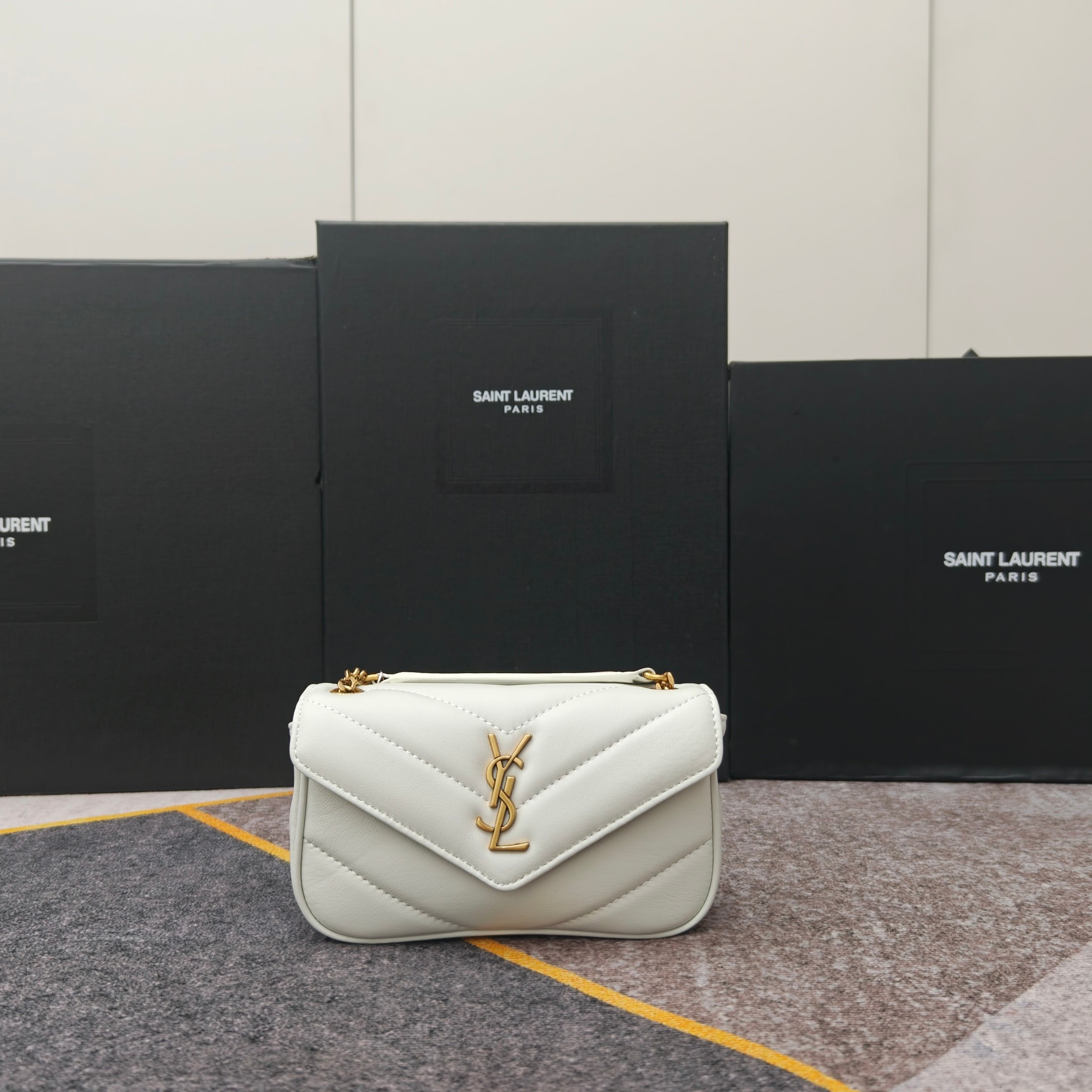 6007白色金扣早春新款𝗟𝗼𝘂𝗟𝗼信封式手袋，很有光泽感，饰以人字纹绗缝明缝线。轻便设计，配有可拆卸卡包