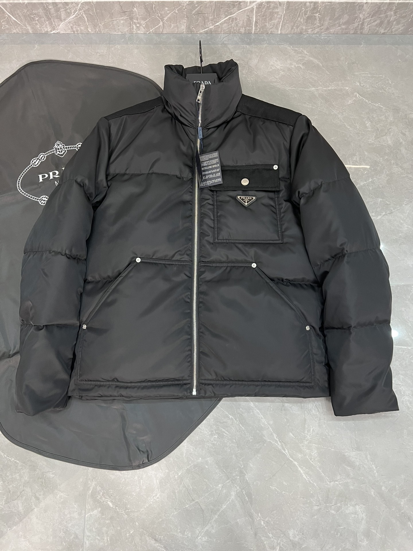 NO:629728,Prad's flagship item in the cabinet. 320 grams of cashmere content. New autumn and winter men's stand-up collar spliced fabric down jacket. Ordered by a trading company. It is a warm outerwear in extremely cold weather. Each down jacket must be temperature tested to achieve the best outdoor wearing effect. It is both warm and fashionable. The upper body has an excellent silhouette. Customized fabrics are supplied by Italian customers. The visual effect is super. The warmth retention, wind resistance and waterproof performance are all top-notch. The latest down jackets are released at the counter.  Using counter 90 white duck down and 10 feathers, it is the standard for the most high-end down jackets  , contains three layers of anti-drilling wool lining, which will never run away. It is filled with 90% imported international new standard white duck down. It is fluffy, thick and warm, with strong resilience and no pressure to cope with the cold winter. Exported by trading companies, foreign orders, classic solid color design, original hardware accessories, fashionable and generous, all details are meticulous, world-class design, absolutely versatile, a must-have in autumn and winter, a warm and warm product that can be used for business, leisure and outdoor use. Black Size 48-56 (175)  125 pounds 48) Maximum wear is 200 pounds, prada, prada, jackets & coats, down jacket, alexander wang19860909Prad普拉达 柜子王牌单品.含绒量320克 秋冬新款男士立领拼接面料羽绒服外套.贸易公司订单,极端寒冷的天气里的御寒外衣,每件羽绒衣都要经过温度测试,以达到最好的室外穿着效果,保暖兼备时尚感, 上身廓形极好,意大利客供定制面料,视觉效果超强.保暖性,防风度,防水性能都是超一流的.专柜最新出炉羽绒服 采用专柜90白鸭绒,10羽毛 ,是最高端羽绒服的标准 ,含三层防钻毛内胆,绝对不会跑绒,内充90进口国际新标白鸭绒,蓬松厚实保暖,回弹力极强,应对寒冬无压力.贸易公司出口,国外订单,经典纯色设计,原版五金辅料,时尚大方,一切细节做到一丝不苟,全球一流设计,绝对百搭无敌,秋冬必备的一款商务休闲户外都可驾驭的保暖胜品.黑色 尺码48-56（175 125斤48）最大穿200斤,,prada,prada,jackets & coats,down jacket,alexander wang,Men's clothing