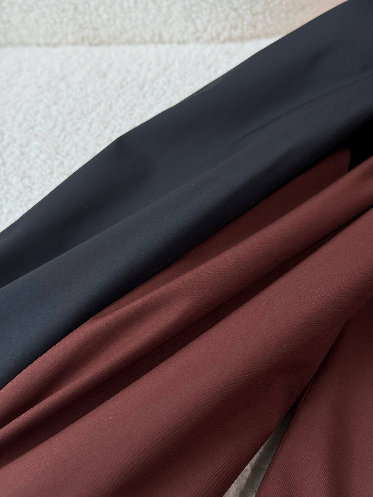 提供暗红色和黑色两种颜色选择，款式为立领休闲夹克，整体风格偏向经典、低调奢华的“老钱风”，剪裁得体，线条