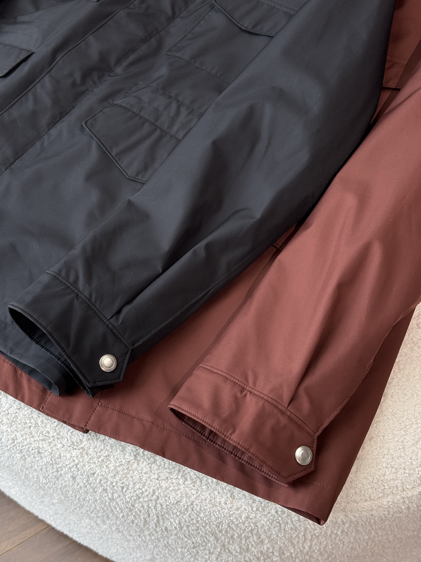 提供暗红色和黑色两种颜色选择，款式为立领休闲夹克，整体风格偏向经典、低调奢华的“老钱风”，剪裁得体，线条