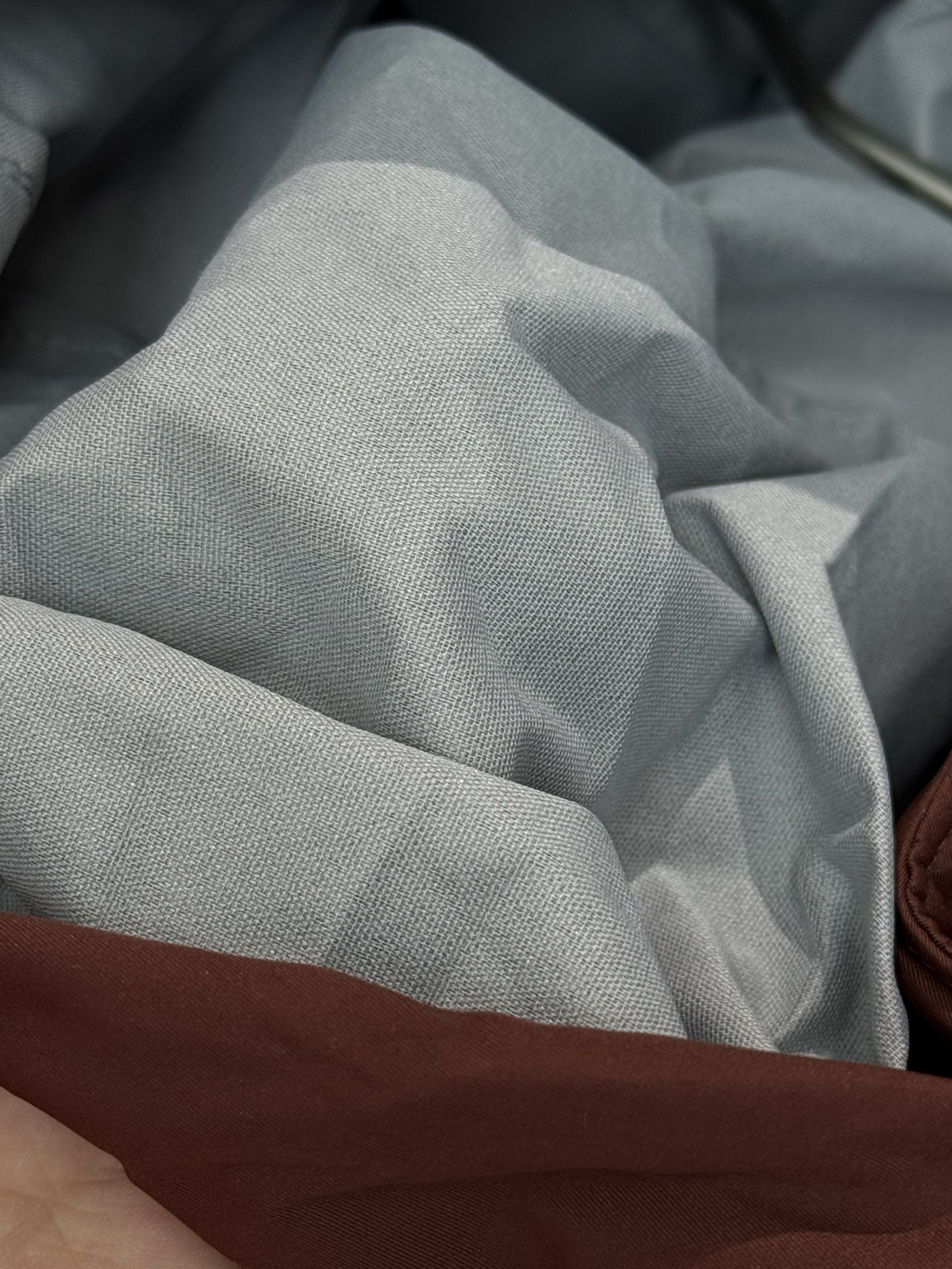 带有可藏式连帽设计，帽子内部衬里颜色与外套内里相呼应，满足不同穿搭需求和天气变化，增加了外套的实用性和穿