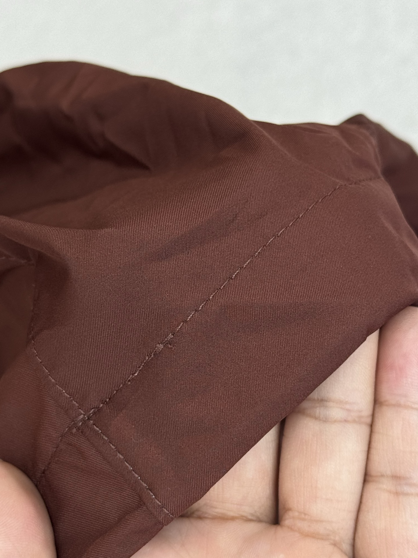 带有可藏式连帽设计，帽子内部衬里颜色与外套内里相呼应，满足不同穿搭需求和天气变化，增加了外套的实用性和穿