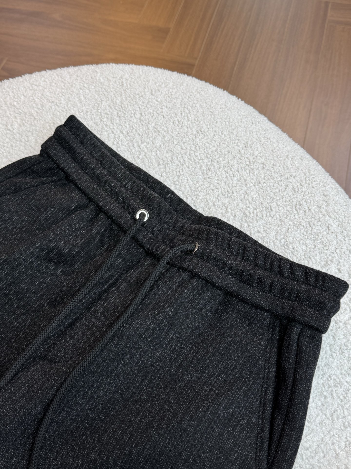 采用抽绳设计，抽绳为黑色编织绳，两端搭配金属质感的圆柱型绳头