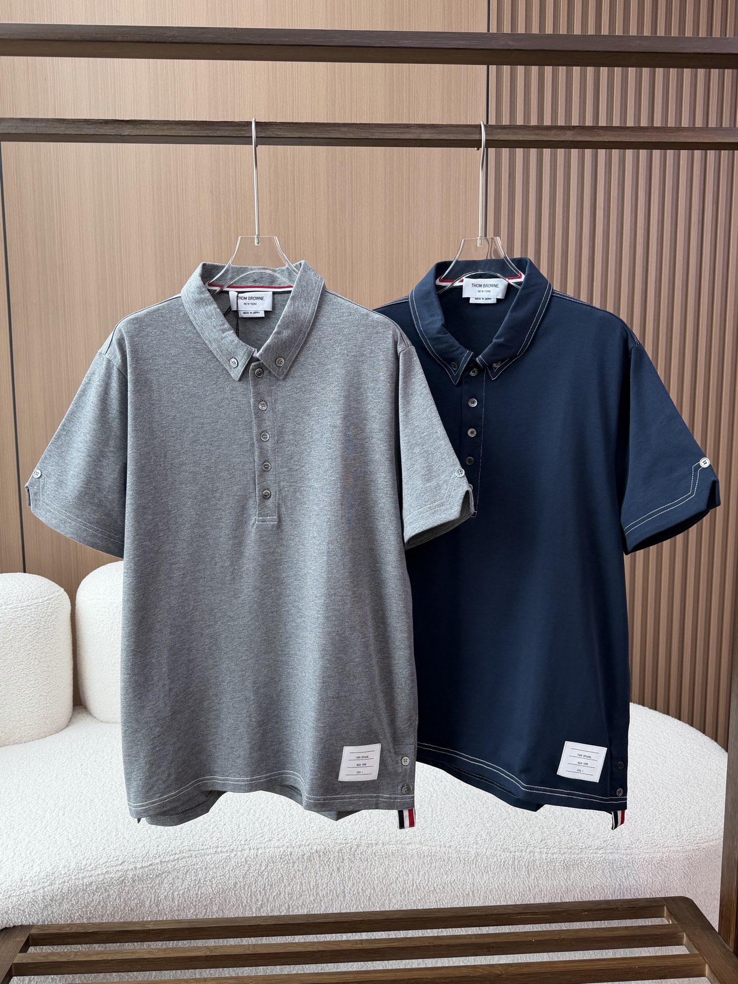 NO:901248,(Quality praise) THOM BROWNE TB 26 new lapel striped all-match button d men's short-sleeved T-shirt polo shirt. Iconic college style and American casual combination, famous for the iconic red, white and blue stripes and exquisite tailoring. Combed cotton pique mesh fabric, breathable and sweat-wicking, soft to the touch and crisp and stylish. Using high-count dense weaving technology, the cloth surface is fine and smooth, not easy to pilling and deformation. The interior is lined with cotton of the same color, which is skin-friendly and non-irritating, making it comfortable and non-restrictive to wear. Classic lapel design, double buttons are used to fix the collar corners to prevent roll-up and maintain clean lines. The brand's iconic red, white and blue webbing is embedded on the inside of the collar, low-key highlighting the identity. There is a round button in the center of the back collar, with a webbing label of the same color, with exquisite details. The placket is designed with multiple natural shell buttons. The surface of the button has a fine texture and a warm luster. The placket adopts double-thread open-stitch technology, with neat routing and fine and even stitching, highlighting high-end quality. Standard short-sleeved cut, moderate sleeve length, fitting the arm line. There is an adjustment button at the cuffs, with V-shaped open-stitch decoration, which is both practical and design-special sleeves. The cuffs adopt double-needle hemming technology, with neat routing and not easy to fall off. The curved hem design is short in the front and long in the back, which is ergonomic and allows free movement. There are slits on both sides of the hem, and there are two buttons on each slit for easy adjustment of the tightness. The red, white and blue three-color webbing is embedded on the inside of the iconic webbing slit, echoing the back collar webbing, enhancing brand recognition. The brand's iconic white cloth label is sewn on the left side of the side hem, with information such as 'THOM BROWNE NEW YORK SIZE 1' printed on it. The colors are available in two classic colors, heather gray and navy blue, which are versatile and easy to match. The version adopts the brand's iconic slim fit, with a neat and stylish upper body that is not flattering on your figure, Thom browne, T-shirt, tees, t-shirt,19860909（品质赞） THOM BROWNE汤姆布朗TB 26新品翻领条纹百搭纽扣d男短袖T恤polo衫 标志性学院风与美式休闲结合,以标志性红白蓝条纹和精致剪裁著称 精梳棉珠地网眼面料,透气排汗,触感柔软且挺括有型 采用高支密织技术,布面细腻平整,不易起球变形 内里同色棉质衬里,亲肤不刺激,穿着舒适无束缚 经典翻领设计,领角采用双纽扣固定,防止翻卷,保持利落线条 领口内侧嵌入品牌标志性红白蓝三色织带,低调彰显身份 后领中央设有一颗圆形纽扣,搭配同色织带标签,细节精致 门襟半开襟设计,采用多颗天然贝壳纽扣,纽扣表面带有细腻纹理,光泽温润 走线门襟处采用双线明线工艺,走线工整,针脚细密均匀,彰显高端品质 标准短袖剪裁,袖长适中,贴合手臂线条袖口处设有一颗调节纽扣,搭配V形明线装饰,既实用又具设计感～特别的袖子 袖口采用双针锁边工艺,走线工整,不易脱线 前短后长的弧形下摆设计,符合人体工学,活动自如 两侧下摆设有开衩,开衩处各有两颗纽扣,方便调节松紧 标志性织带开衩内侧嵌入红白蓝三色织带,与后领织带呼应,强化品牌辨识度 侧标下摆左侧缝制品牌标志性白色布标,印有“THOM BROWNE NEW YORK SIZE 1”等信息 颜色提供麻灰色与藏青色两种经典配色,百搭易搭 版型采用品牌标志性的修身剪裁,上身利落有型,不挑身材,,thom browne,T-shirt,tees，t-shirt,,Women's clothing
