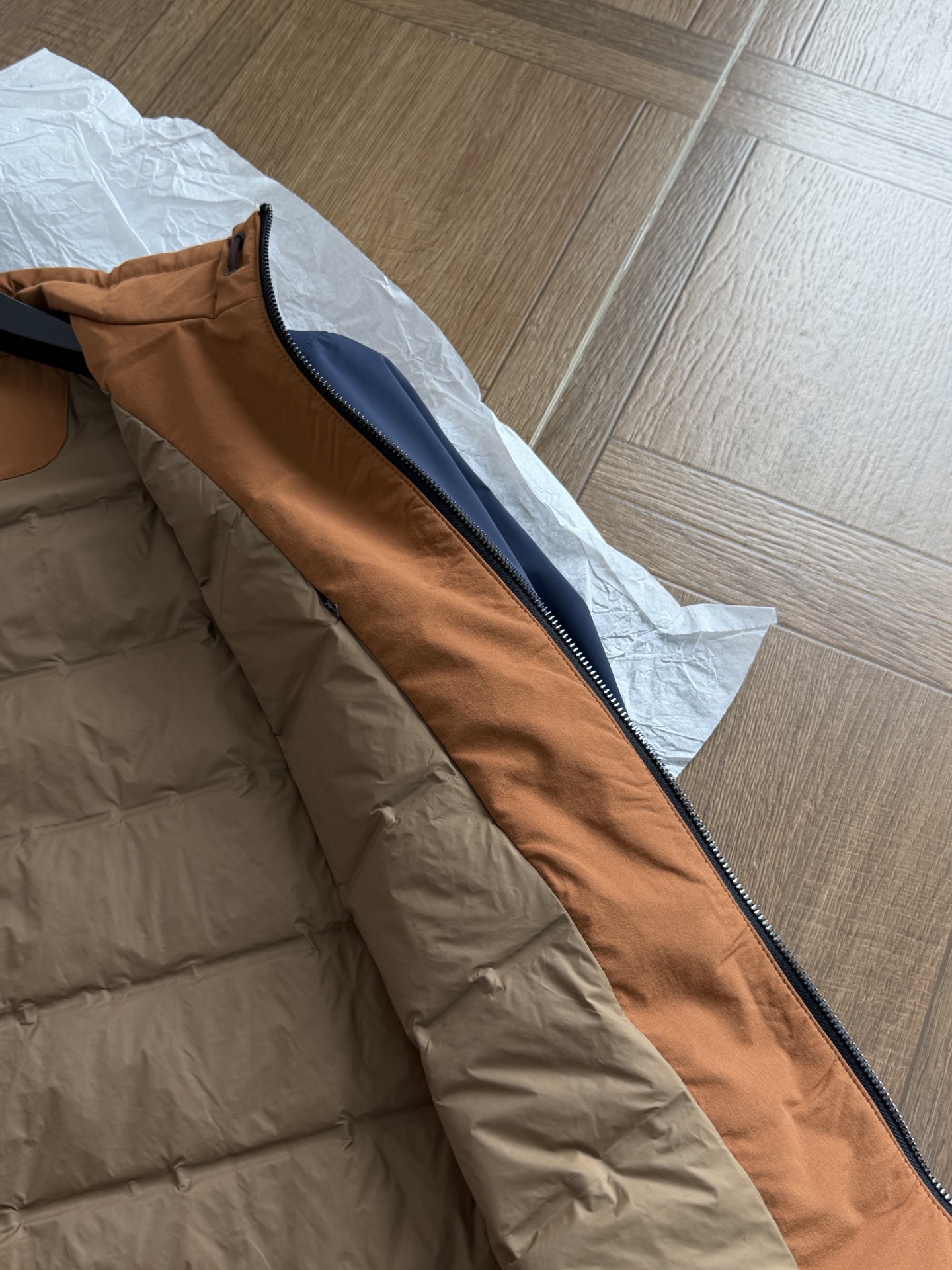羽绒服  内里填充白鸭绒 内里撞色暖棕‑卡其配色，领内侧缝制品牌织唛标签；内里采用定点压胶绗缝工艺，薄款白鸭绒填充，均匀
