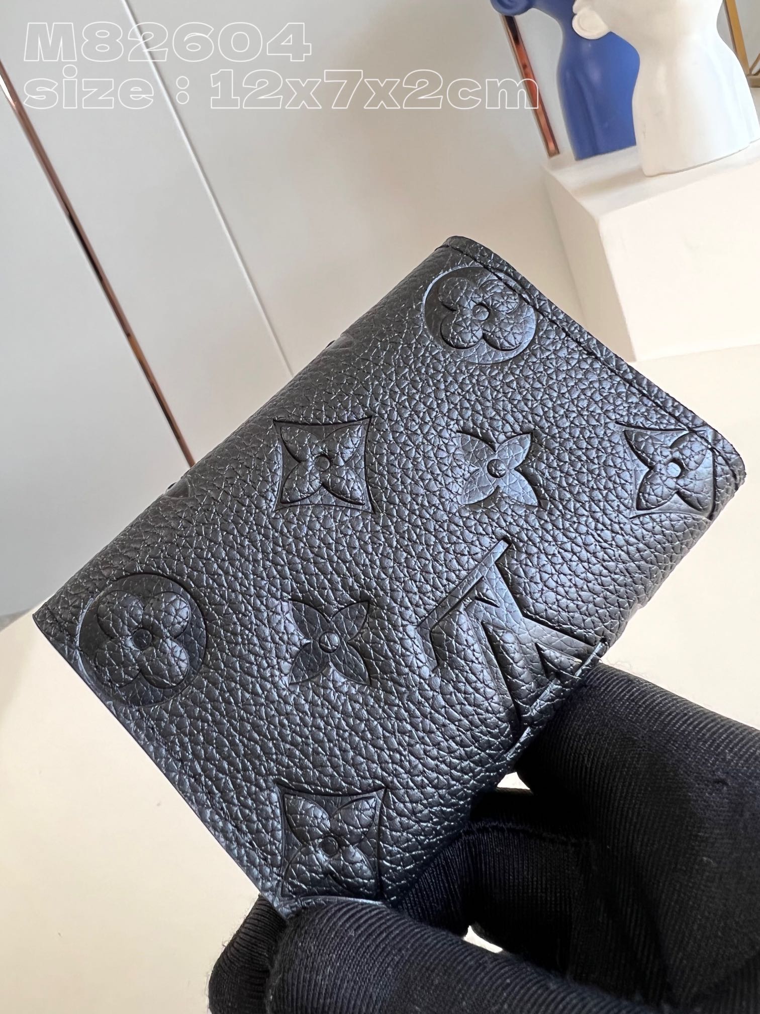 M82604黑压花 】本款钥匙包将 LV 字母和 Monogram 花簇图案化为全粒面 Taurillon 皮革的细腻压纹,搭配按扣开合 3