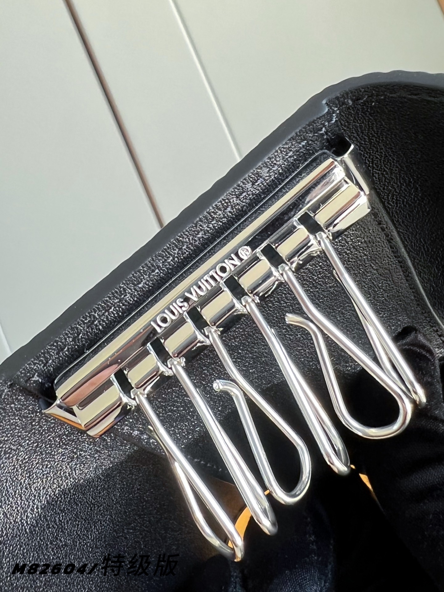 【 M82604/特级全钢版 】本款钥匙包将 LV 字母和 Monogram 花簇图案化为全粒面 Tau