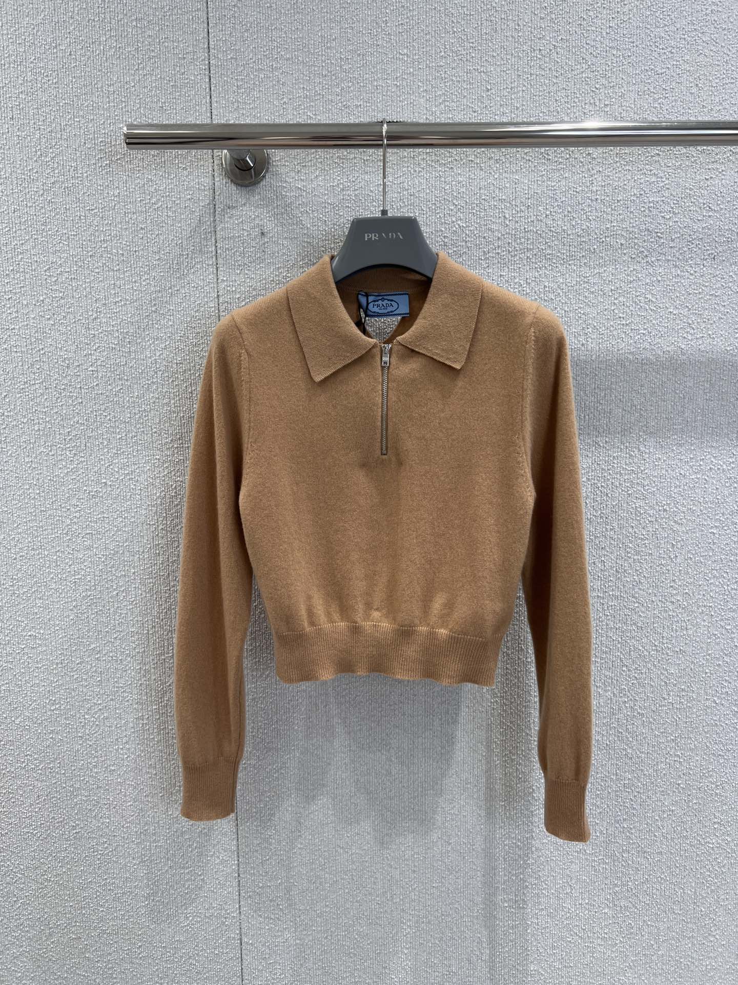 NO:488054,Support replacement Prad* 25Fw early autumn new style cashmere lapel semi-zipper sweater | Exclusive high-end product!  The elegant outline is outlined in soft camel color, and the slim short cut shows the neat shoulder and neckline. The iconic triangle logo on the back is cleverly echoing, reinterpreting the classic logo, hiding brand recognition in simplicity; the delicate knitted fabric is skin-friendly and comfortable, and the semi-zippered neckline adds casualness, which can be easily adapted to workplace commuting and casual dates, and reveals low-key luxury in every move. S/M/L real-life details pictures, prada, alexander wang19860909支持换款 Prad* 25Fw早秋新款 山羊绒翻领半拉链针织衫丨独家高版出品！以柔和驼色勾勒优雅轮廓,修身短款剪裁尽显利落肩颈线.后背标志性三角标镂空设计巧妙呼应,重新诠释经典徽标,在简约中暗藏品牌辨识度；细腻针织面料亲肤舒适,半拉链领口增添随性感,可轻松适配职场通勤与休闲约会,举手投足间流露低调奢华.现货发售S/M/L实拍细节图,,prada,alexander wang,Women's clothing